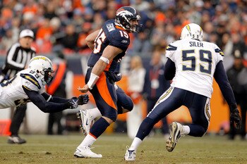 DENVER, CO - JANUARY 2:  Quarterback Tim Tebow #15 of the Denver Broncos eludes linebacker Kevin Burnett #99 and linebacker Brandon Siler #59 of the San Diego Chargers during the third quarter at INVESCO Field at Mile High on January 2, 2011 in Denver, Co