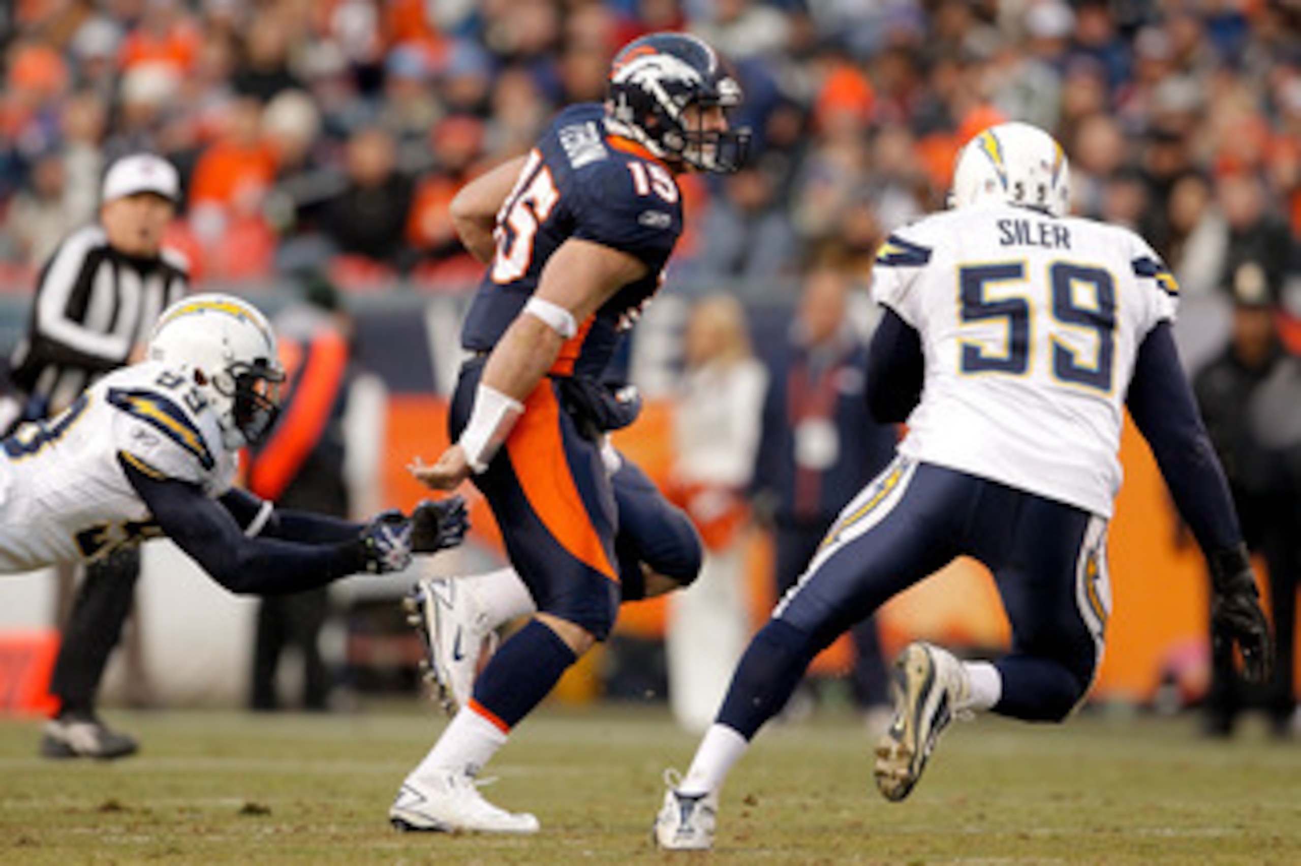 DENVER, CO - JANUARY 2:  Quarterback Tim Tebow #15 of the Denver Broncos eludes linebacker Kevin Burnett #99 and linebacker Brandon Siler #59 of the San Diego Chargers during the third quarter at INVESCO Field at Mile High on January 2, 2011 in Denver, Co
