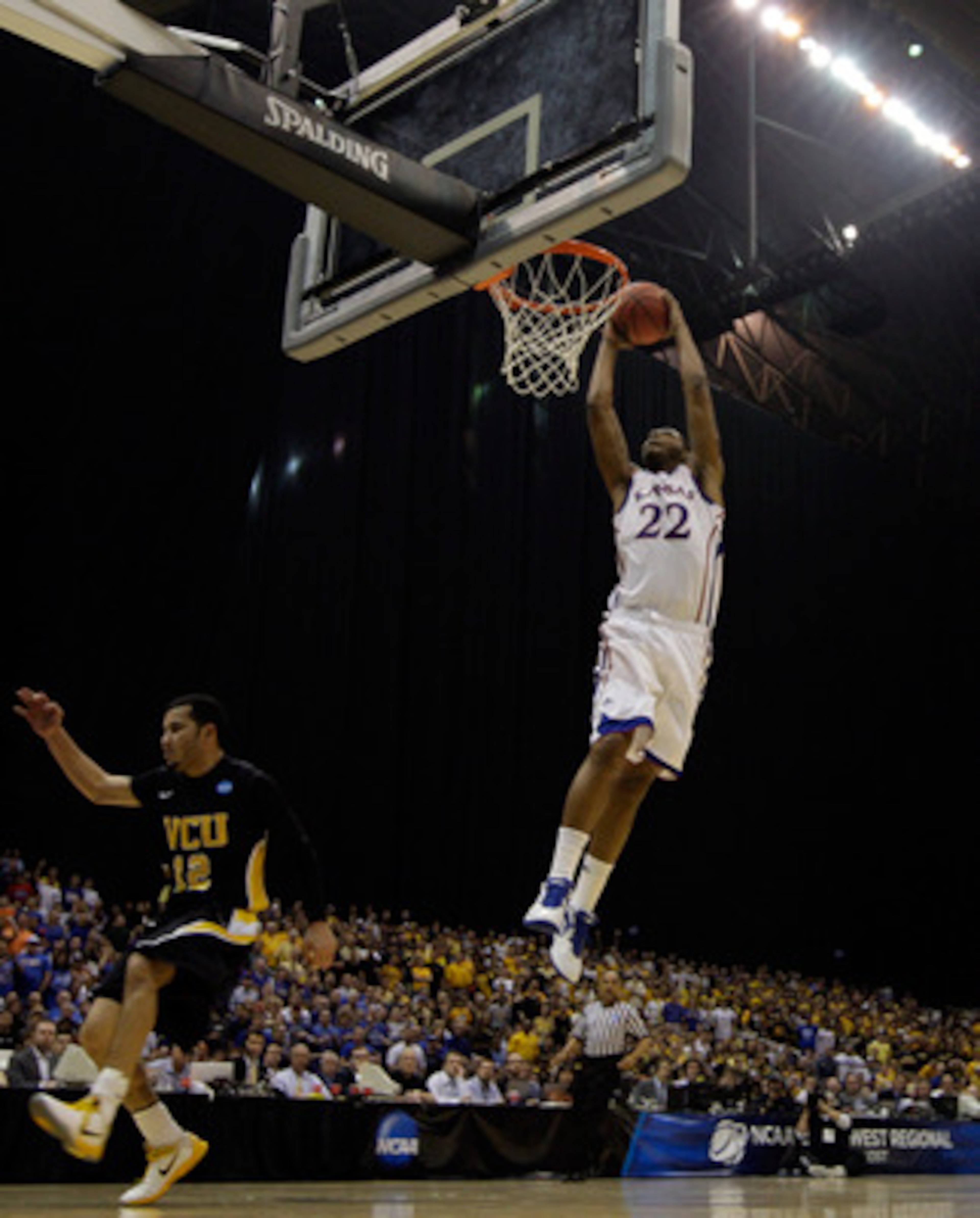 SAN ANTONIO, TX - MARCH 27:  Marcus Morris #22 of the Kansas Jayhawks dunks against Joey Rodriguez #12 of the Virginia Commonwealth Rams during the southwest regional final of the 2011 NCAA men's basketball tournament at the Alamodome on March 27, 2011 in