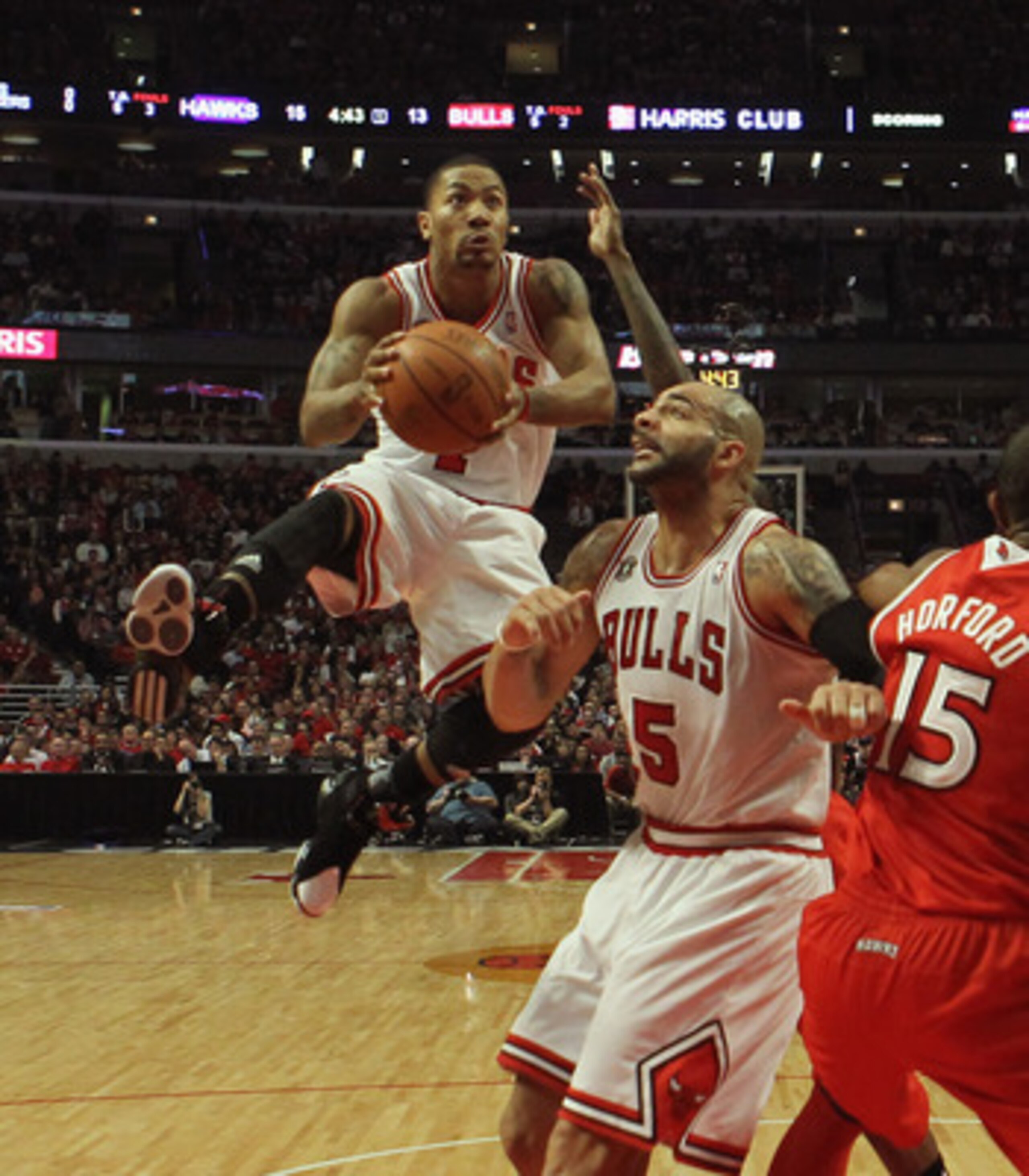 CHICAGO, IL - MAY 04: Derrick Rose #1 of the Chicago Bulls goes up for a shot over teammate Carlos Boozer #5 and Al Horford #15 of the Atlanta Hawks in Game Two of the Eastern Conference Semifinals in the 2011 NBA Playoffs at the United Center on May 4, 2