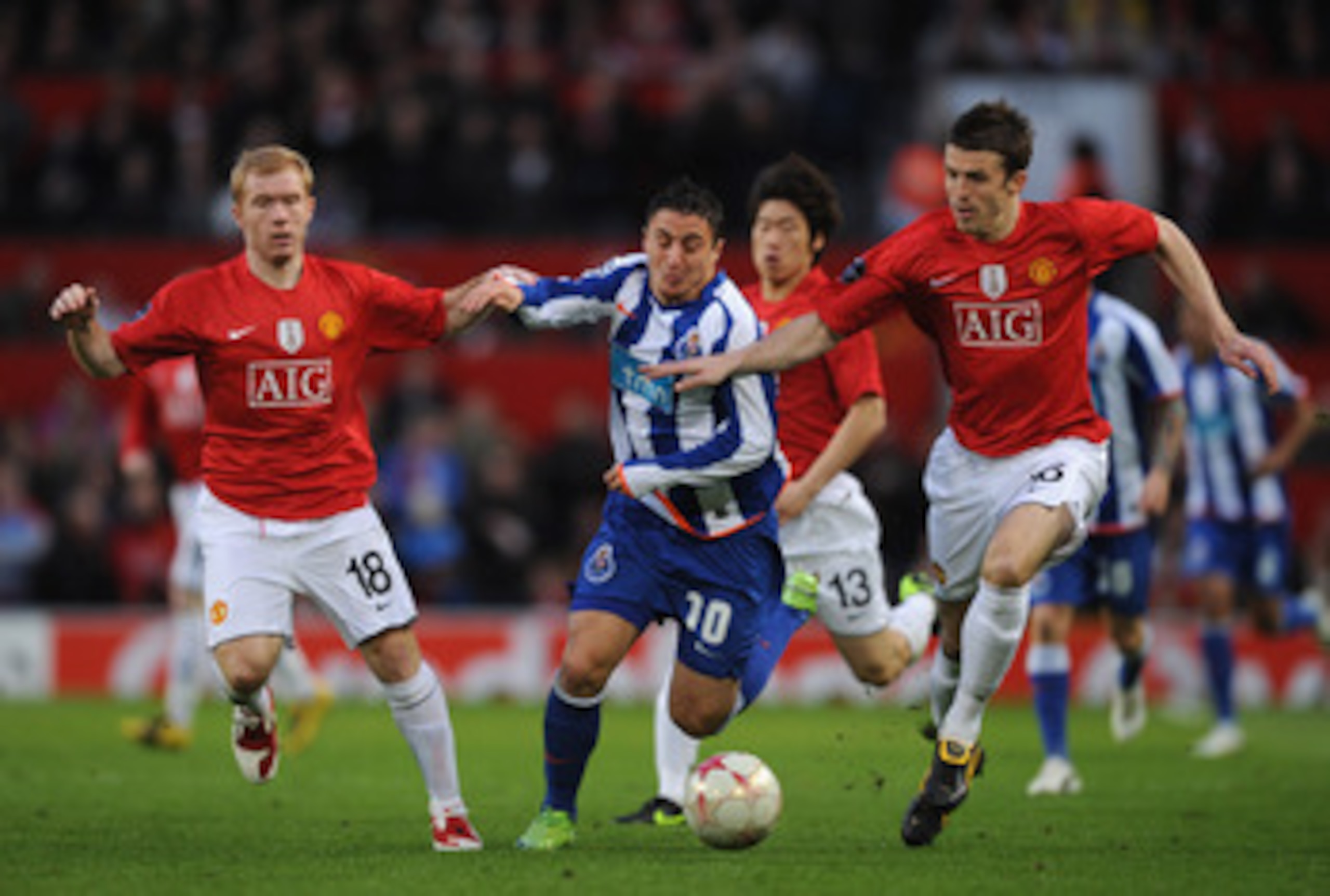 MANCHESTER, ENGLAND - APRIL 07:  Cristian Rodriguez of FC Porto battles with Michael Carrick and Paul Scholes of Manchester United during the UEFA Champions League Quarter Final First Leg match between Manchester United and FC Porto at Old Trafford on Apr