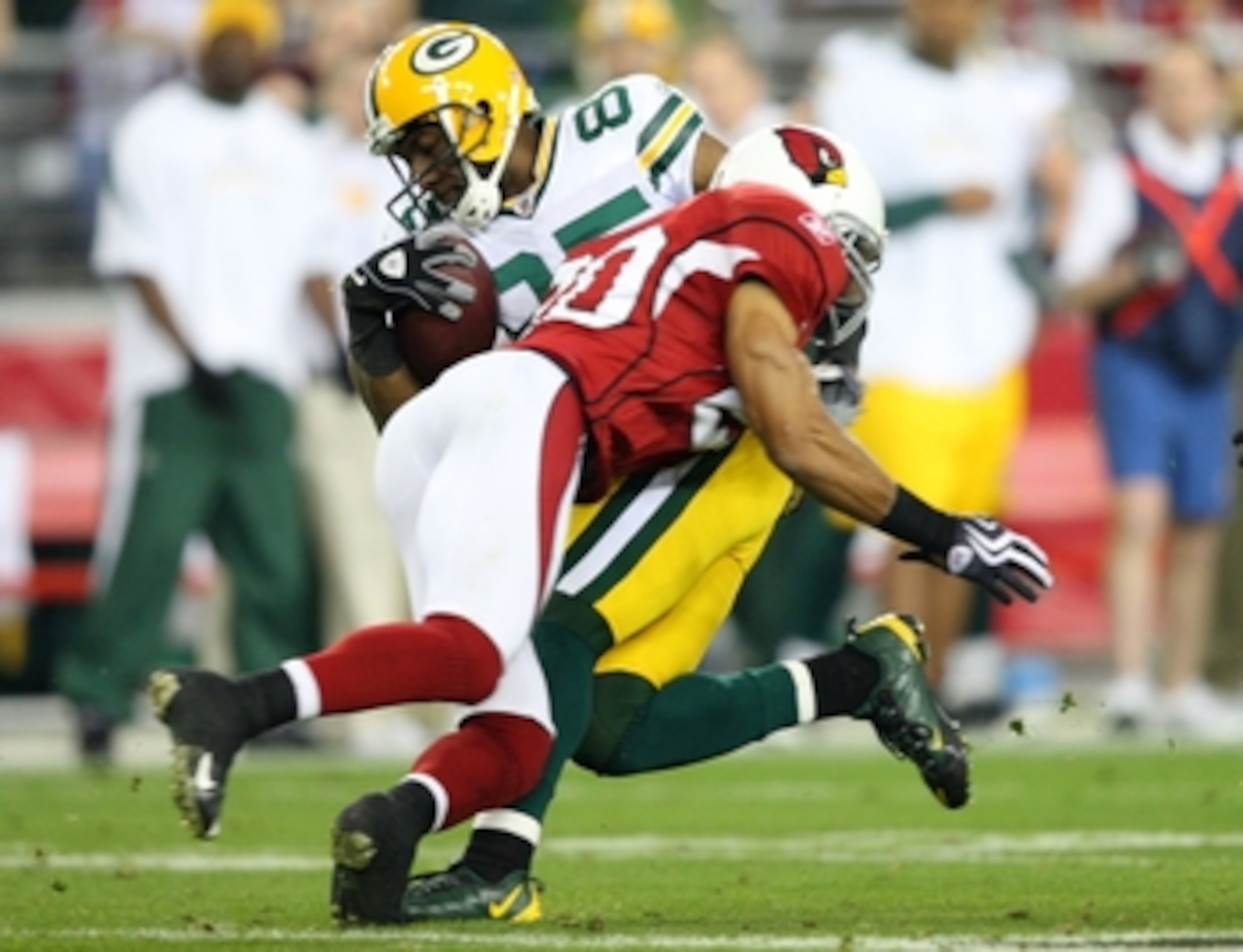 GLENDALE, AZ - JANUARY 10:  Greg Jennings #85 of the Green Bay Packers is hit by Ralph Brown #20 of the Arizona Cardinals during the fourth quarter of the 2010 NFC wild-card playoff game at University of Phoenix Stadium on January 10, 2010 in Glendale, Ar