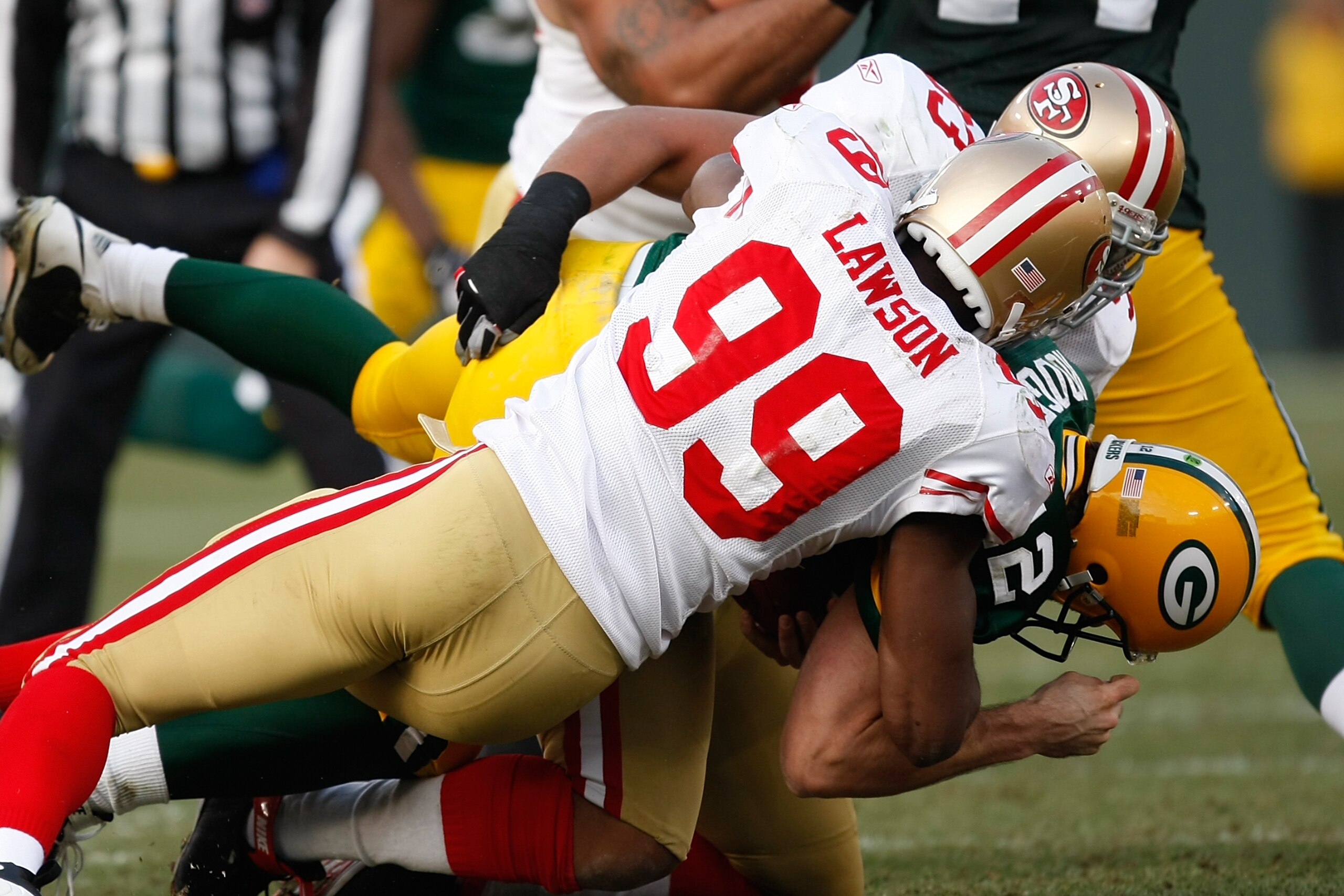 GREEN BAY, WI - NOVEMBER 22: Linebacker Manny Lawson #99 and defensive tackle Demetric Evans #93 of the San Francisco 49ers sacks quarterback Aaron Rodgers #12 of the Green Bay Packers at Lambeau Field on November 22, 2009 in Green Bay, Wisconsin. The Pac