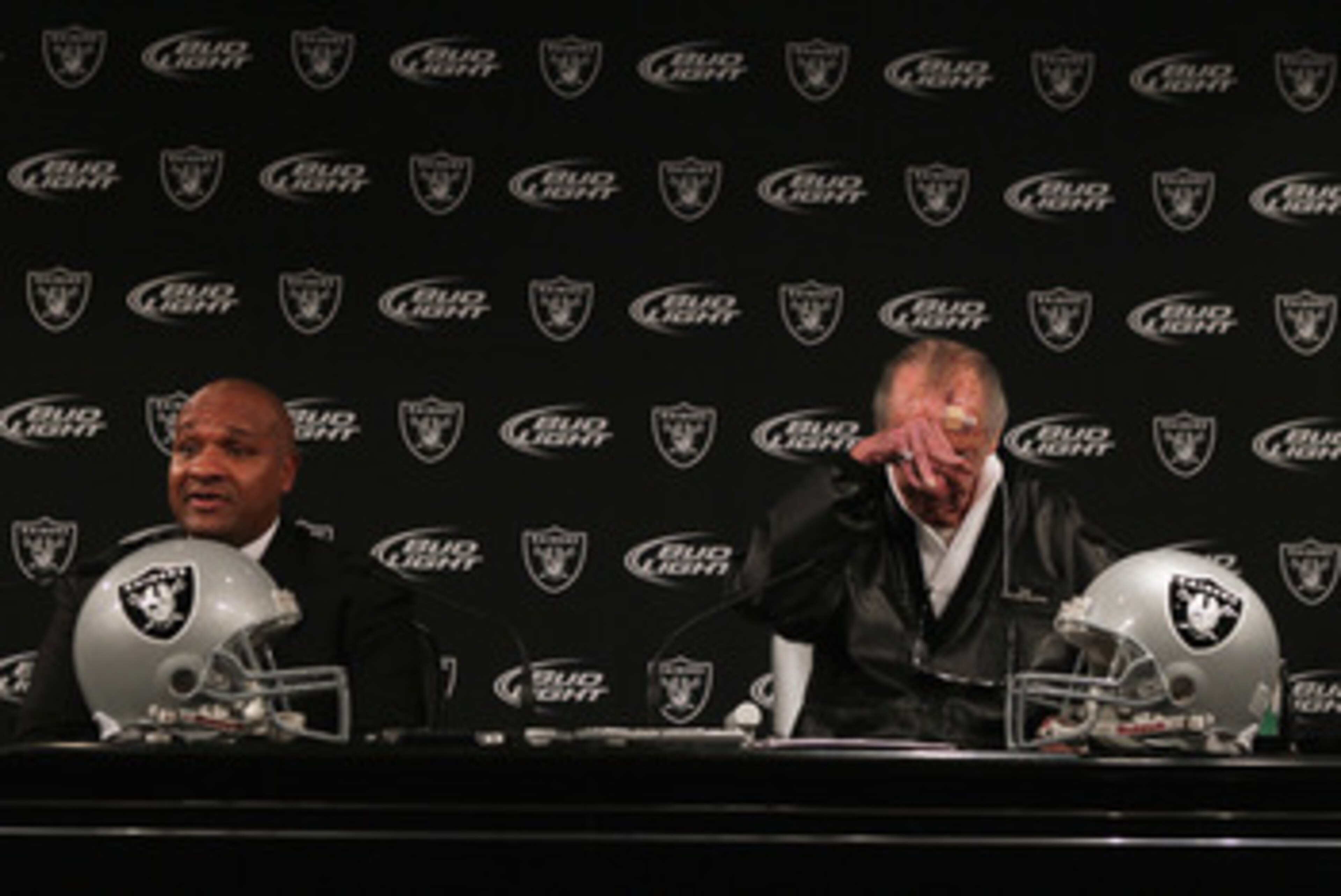 ALAMEDA, CA - JANUARY 18:  New Oakland Raiders coach Hue Jackson (L) speaks to reporters as  Raiders owner Al Davis rubs his head during a press conference on January 18, 2011 in Alameda, California. Hue Jackson was introduced as the new coach of the Oakl