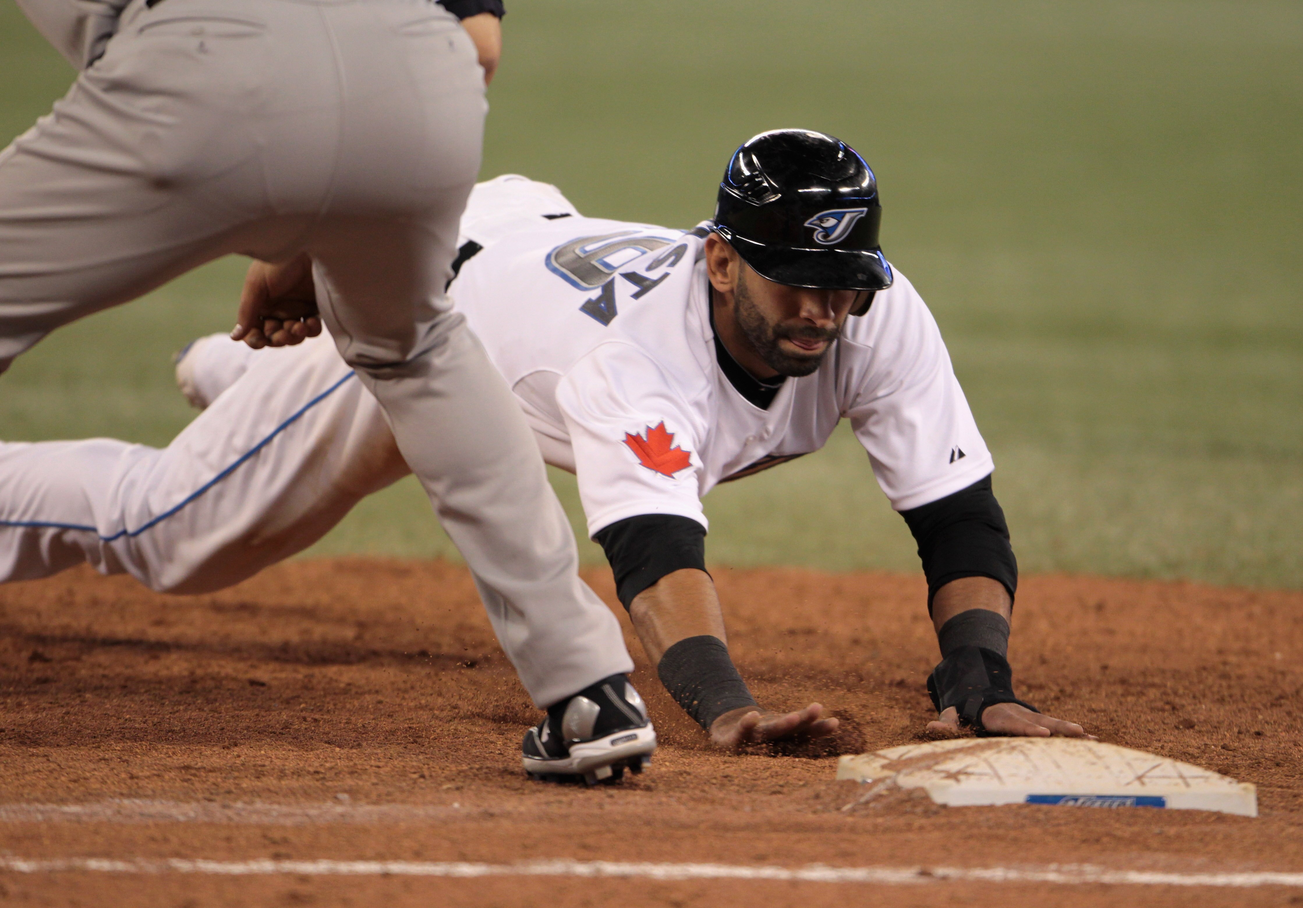 TORONTO, ON - APRIL 19:  Jose Bautista #19 of the Toronto Blue Jays dives back into first base during their game against the New York Yankees at Rogers Centre on April 19, 2011 in Toronto, Canada.  (Photo by Scott Halleran/Getty Images)