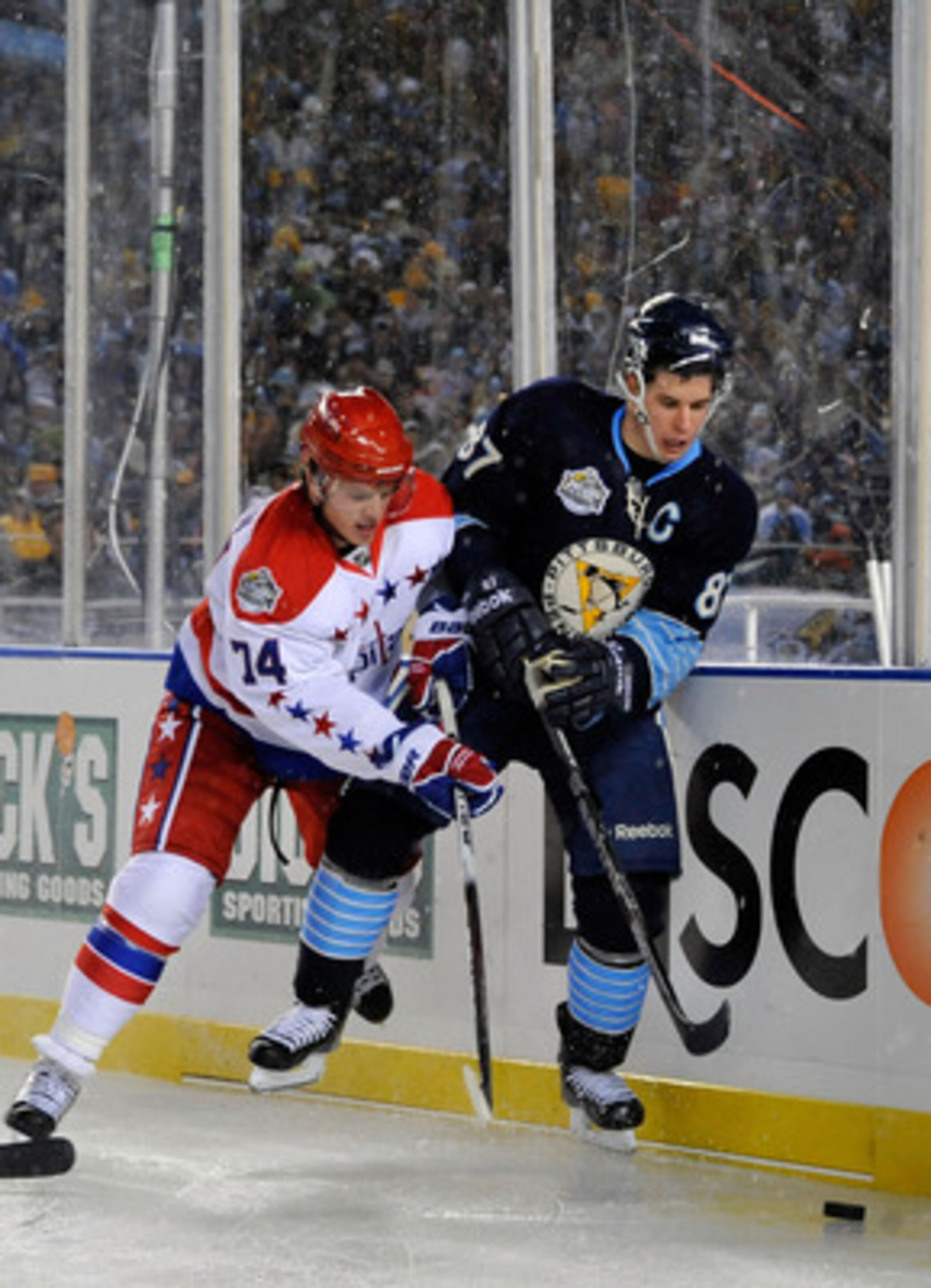 PITTSBURGH, PA - JANUARY 01: Sidney Crosby #87 of the Pittsburgh Penguins battles for the puck against John Carlson #74 of the Washington Capitals during the 2011 NHL Bridgestone Winter Classic at Heinz Field on January 1, 2011 in Pittsburgh, Pennsylvani PITTSBURGH, PA - JANUARY 01: Sidney Crosby #87 of the Pittsburgh Penguins battles for the puck against John Carlson #74 of the Washington Capitals during the 2011 NHL Bridgestone Winter Classic at Heinz Field on January 1, 2011 in Pittsburgh, Pennsylvani