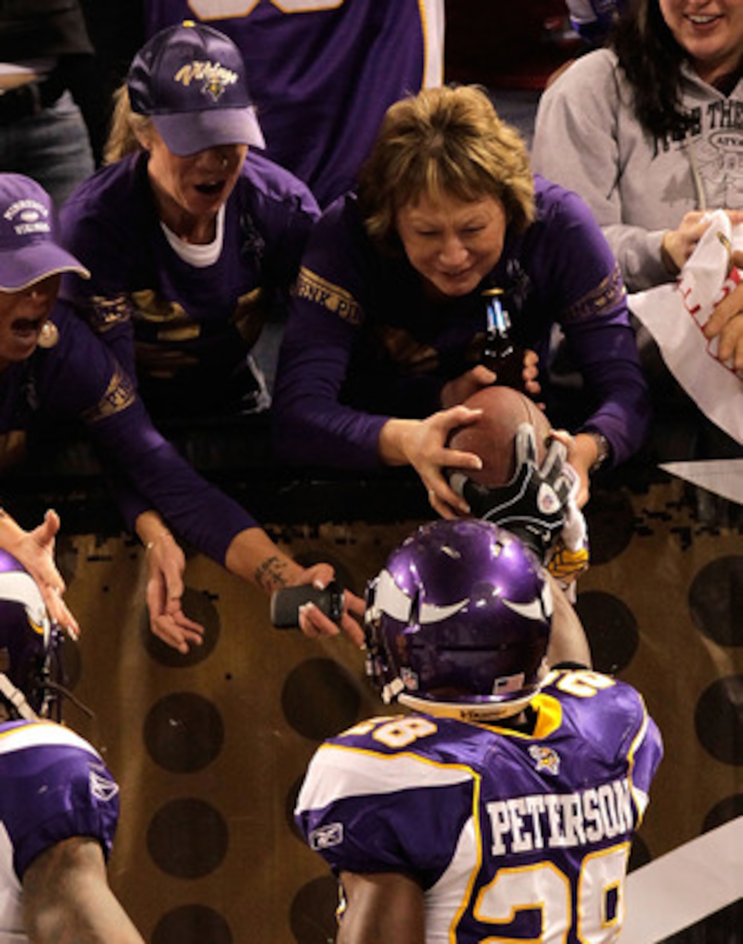 MINNEAPOLIS, MN - DECEMBER 05:  Adrian Peterson #28 of the Minnesota Vikings hands the ball to a fan alongside teammate Sidney Rice #18 after he rushed for a touchdown against the Buffalo Bills at the Mall of America Field at the Hubert H. Humphrey Metrod