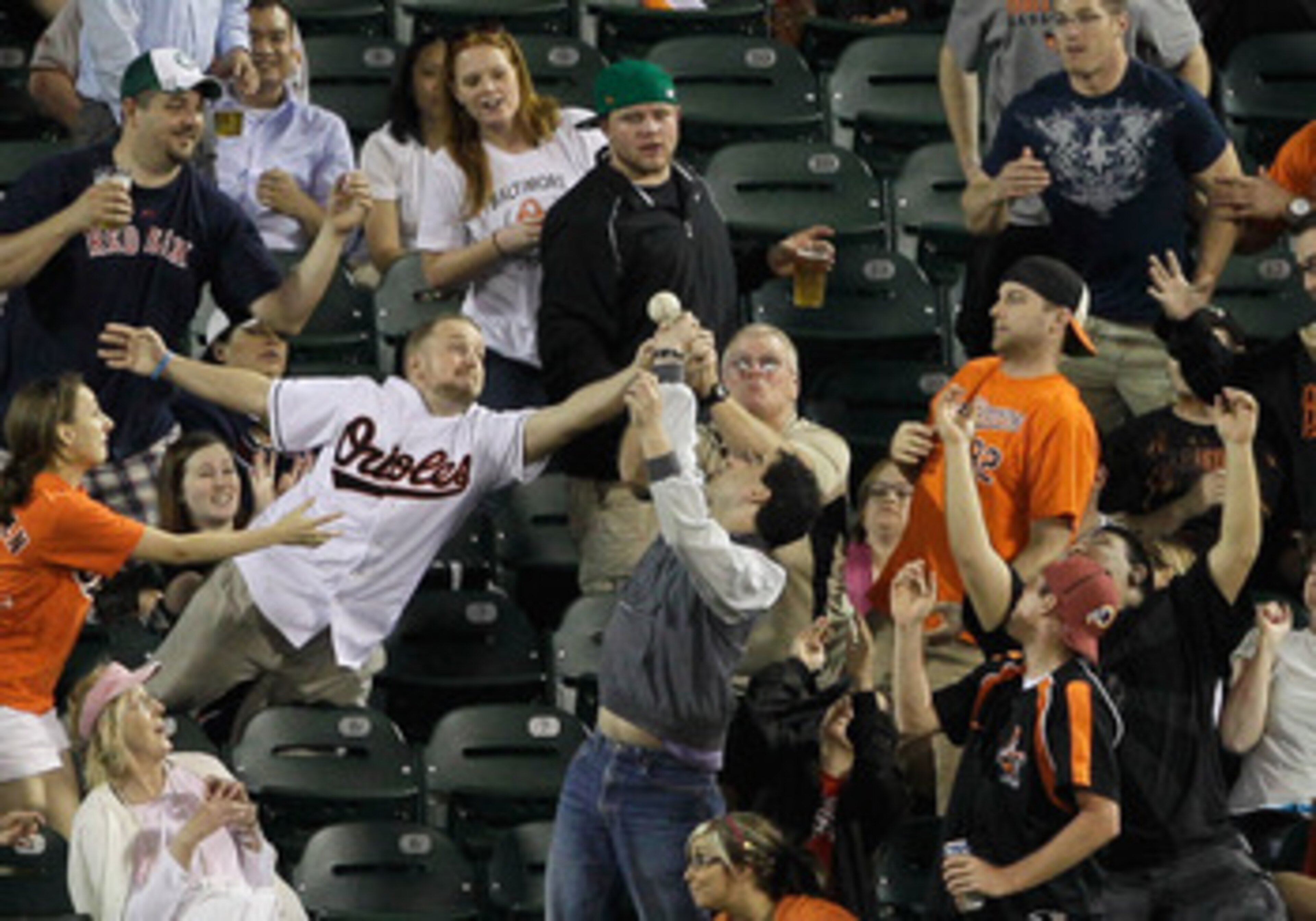 BALTIMORE, MD - APRIL 26:  Fans go after a ball thrown into the outfield after the third out of the sixth inning during the Boston Red Sox and Baltimore Orioles game at Oriole Park at Camden Yards on April 26, 2011 in Baltimore, Maryland.  (Photo by Rob C