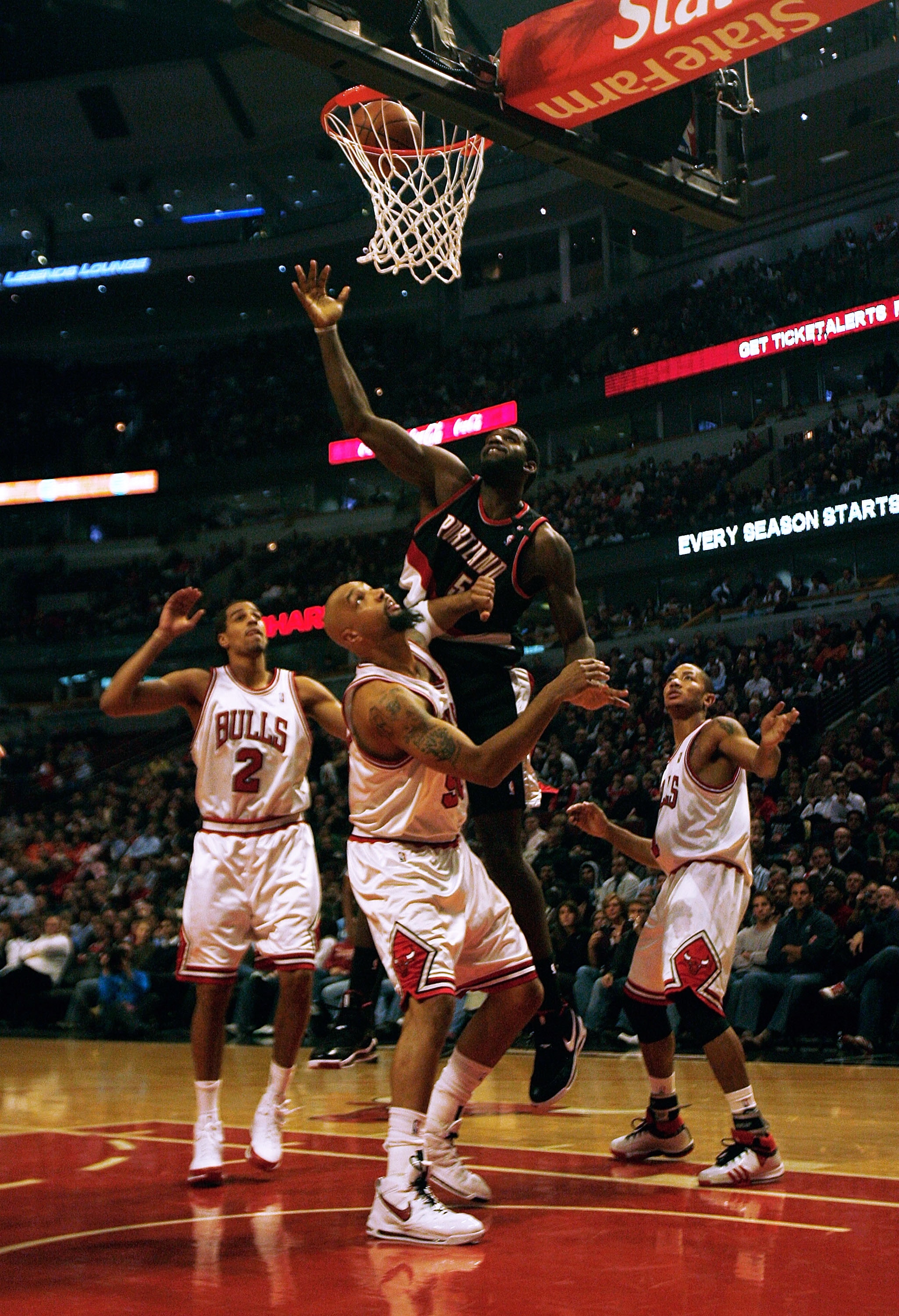 CHICAGO - JANUARY 12: Greg Oden #52 of the Portland Trail Blazers hits a shot under pressure from (L-R) Thabo Sefolosha #2, Drew Gooden #90 and Derrick Rose #1 of the Chicago Bulls on January 12, 2009 at the United Center in Chicago, Illinois. NOTE TO USE