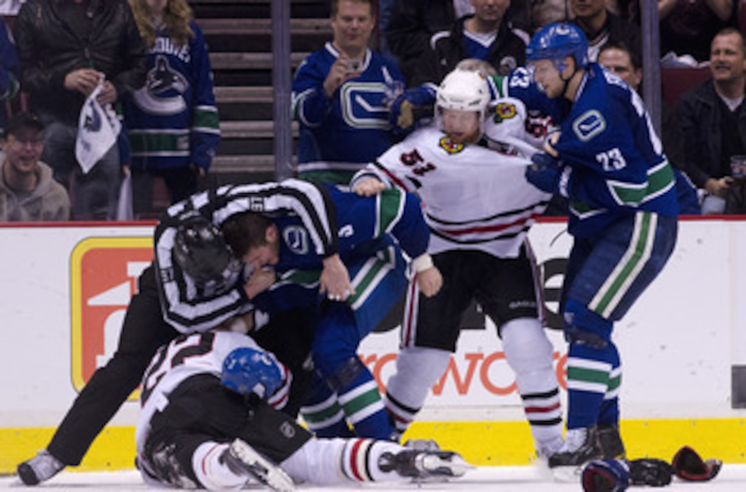 VANCOUVER, CANADA - APRIL 21: Linesman Jean Morin #97 tries to separate Kevin Bieksa #3 of the Vancouver Canucks and Troy Brouwer #22 of the Chicago Blackhawks while Alexander Edler #23 of the Vancouver Canucks  and Brian Campbell #51 of the Chicago Black