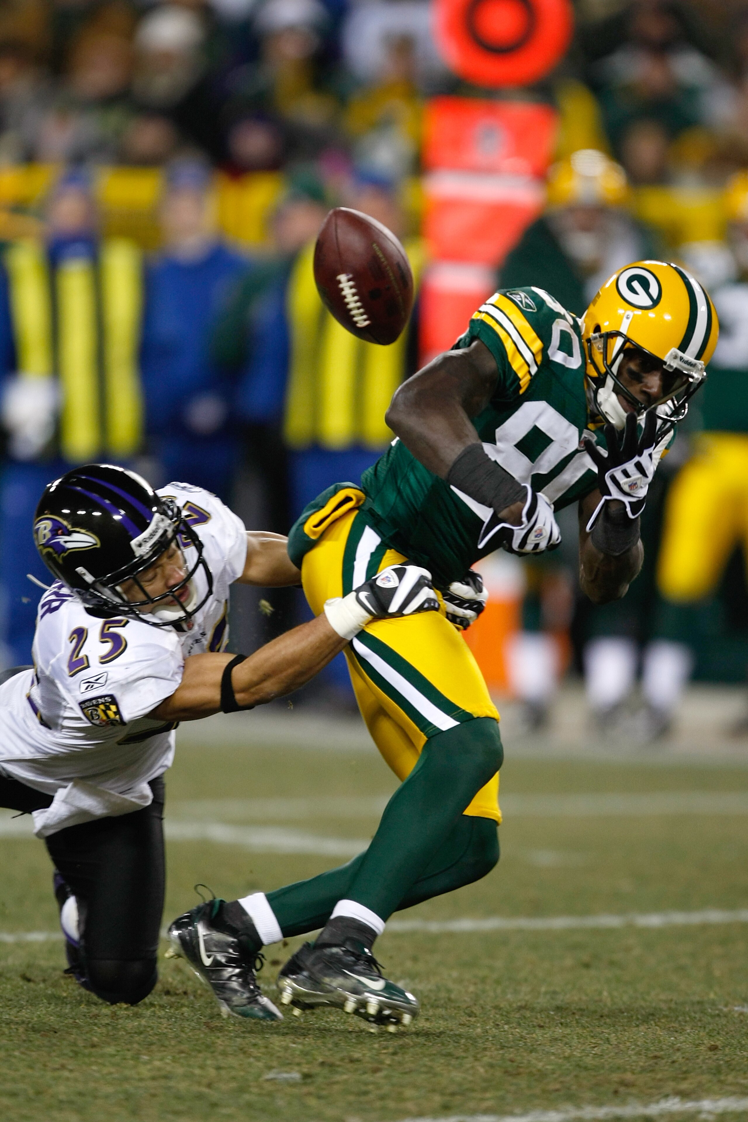 GREEN BAY, WI - DECEMBER 7: Wide receiver Donald Driver #80 of the Green Bay Packers fumbles the football as he is hit by Chris Carr #25 of the Baltimore Ravens at Lambeau Field on December 7, 2009 in Green Bay, Wisconsin. The Packers defeated the Ravens