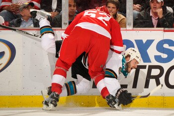 DETROIT - MAY 4:  Jonathan Ericsson #52 of the Detroit Red Wings checks Ian White #9 of the San Jose Sharks in the third period in Game Three of the Western Conference Semifinals during the 2011 NHL Stanley Cup Playoffs on May 4, 2011 at Joe Louis Arena i