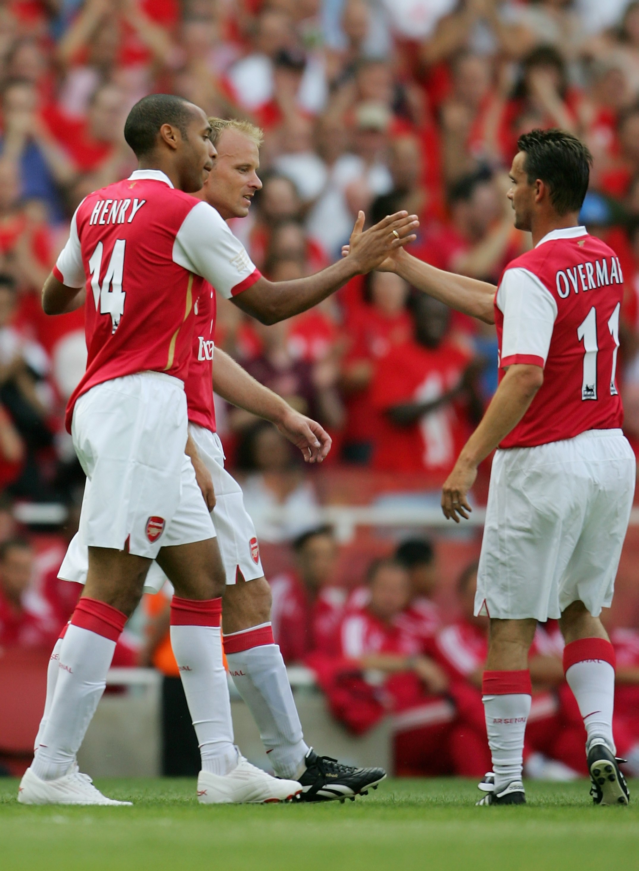 LONDON - JULY 22:  Thierry Henry (L) of Arsenal, is congratulated by teammates Dennis Bergkamp (C) and Marc Overmars (R), after scoring a goal during the Dennis Bergkamp testimonial match between Arsenal and Ajax at the Emirates Stadium on July 22, 2006 i
