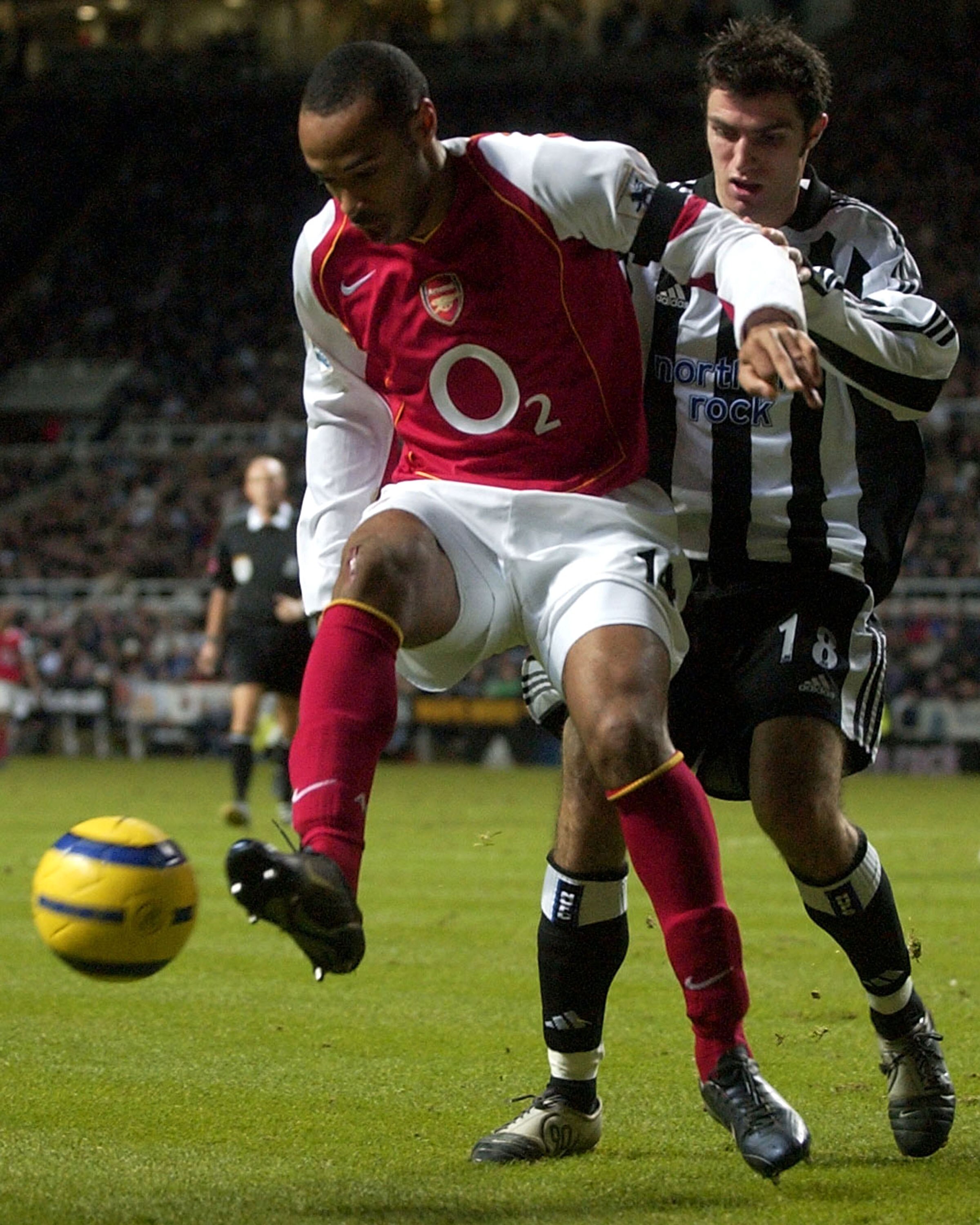 NEWCASTLE, ENGLAND - DECEMBER 29: Thierry Henry of Arsenal holds off Aaron Hughes of Newcastle during the FA Barclays Premiership match between Newcastle United and Arsenal at St.James Park on December 29, 2004 in Newcastle, England. (Photo by Matthew Lew