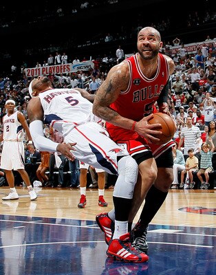 ATLANTA, GA - MAY 06:  Josh Smith #5 of the Atlanta Hawks draws an offensive foul from Carlos Boozer #5 of the Chicago Bulls in Game Three of the Eastern Conference Semifinals in the 2011 NBA Playoffs at Phillips Arena on May 6, 2011 in Atlanta, Georgia.