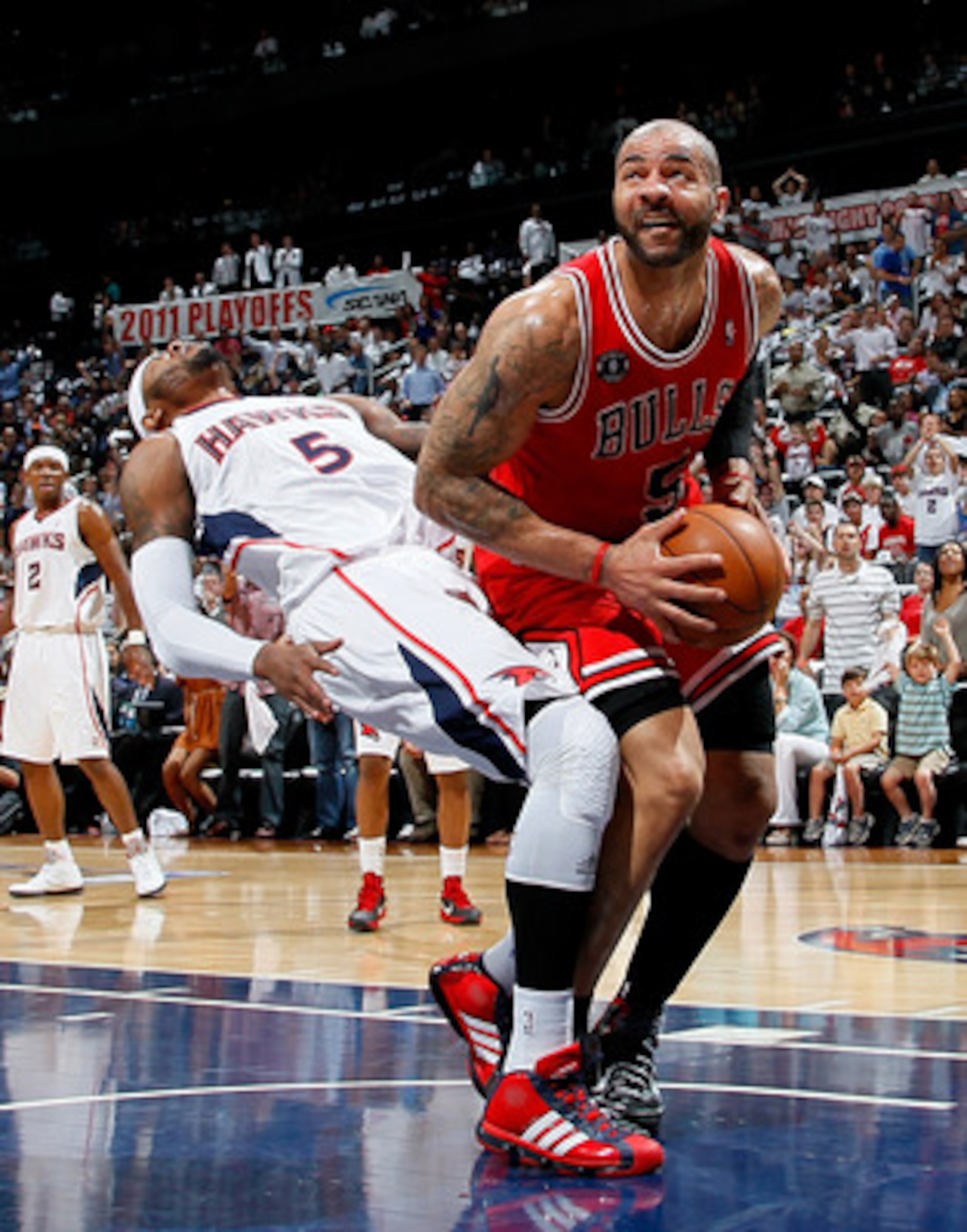 ATLANTA, GA - MAY 06:  Josh Smith #5 of the Atlanta Hawks draws an offensive foul from Carlos Boozer #5 of the Chicago Bulls in Game Three of the Eastern Conference Semifinals in the 2011 NBA Playoffs at Phillips Arena on May 6, 2011 in Atlanta, Georgia.