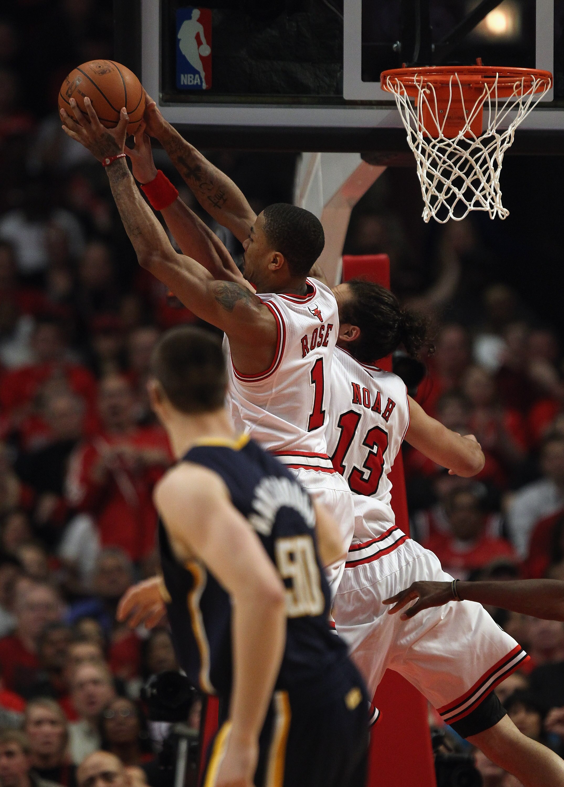 CHICAGO, IL - APRIL 18: Derrick Rose #1 of the Chicago Bulls leaps over teammate Joakim Noah #13 for a rebound as Tyler Hansbrough #50 of the Indiana Pacers watches in Game Two of the Eastern Conference Quarterfinals in the 2011 NBA Playoffs at the United