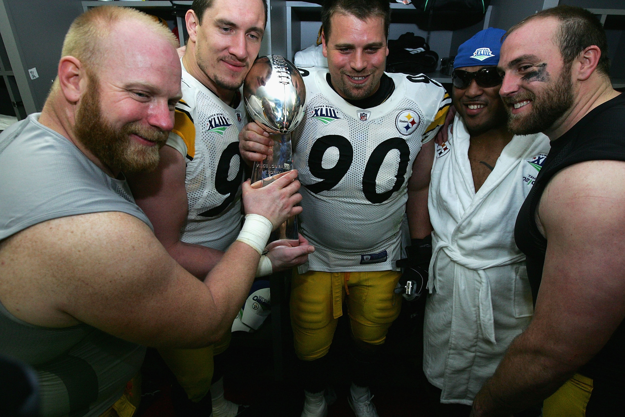 TAMPA, FL - FEBRUARY 01:  (L-R) Chris Hoke #76, Aaron Smith #91 Travis Kirschke #90,  Casey Hampton #98 and Brett Keisel #99 of the Pittsburgh Steelers celebrates with the Vince Lombardi trophy in the locker room after defeating the Arizona Cardinals duri