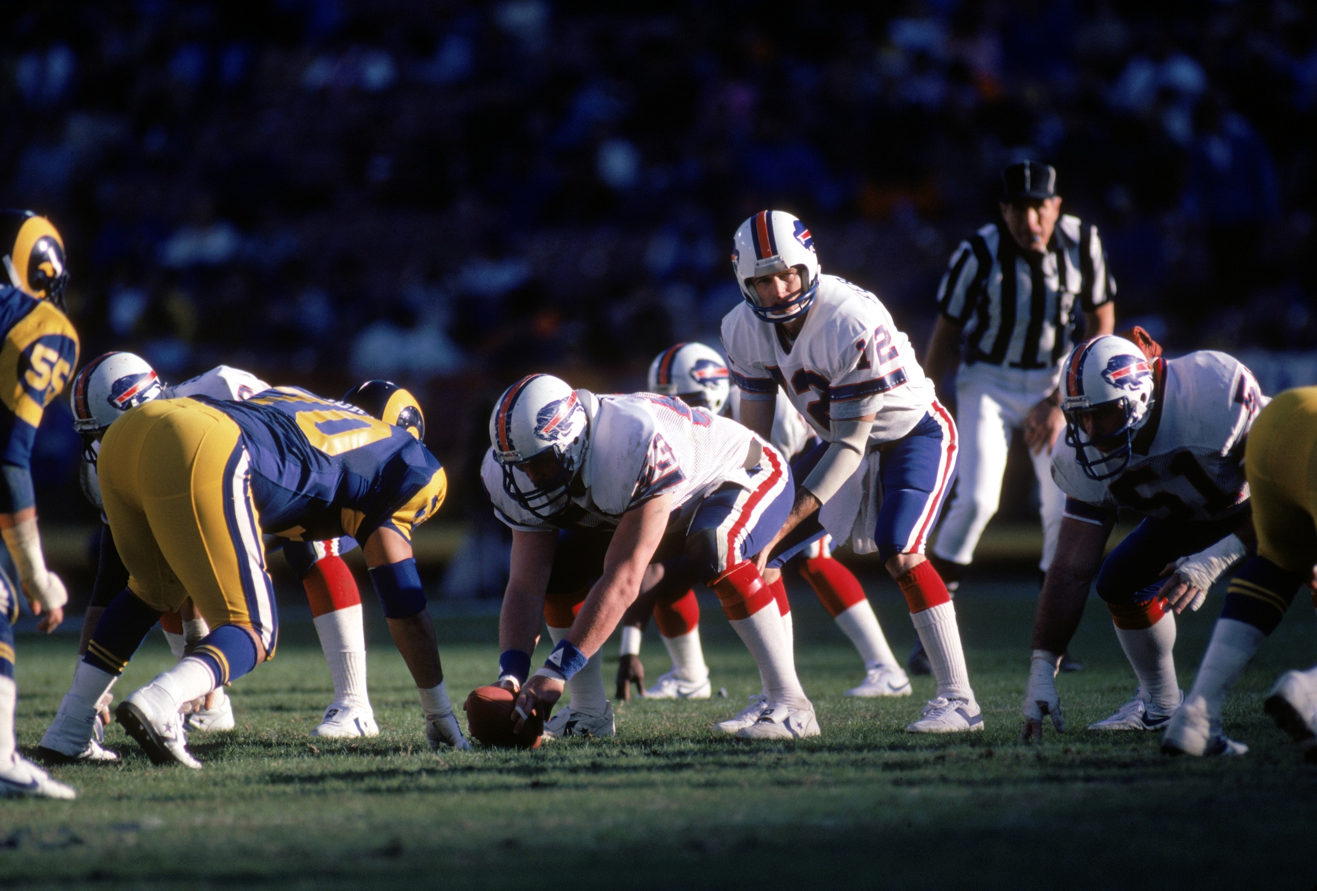 ANAHEIM, CA - NOVEMBER 27:  Quarterback Joe Ferguson #12 of the Buffalo Bills calls a play as he lines up behind center Will Grant #53 during a game against the Los Angeles Rams at Anaheim Stadium on November 27, 1983 in Anaheim, California.  The Rams won