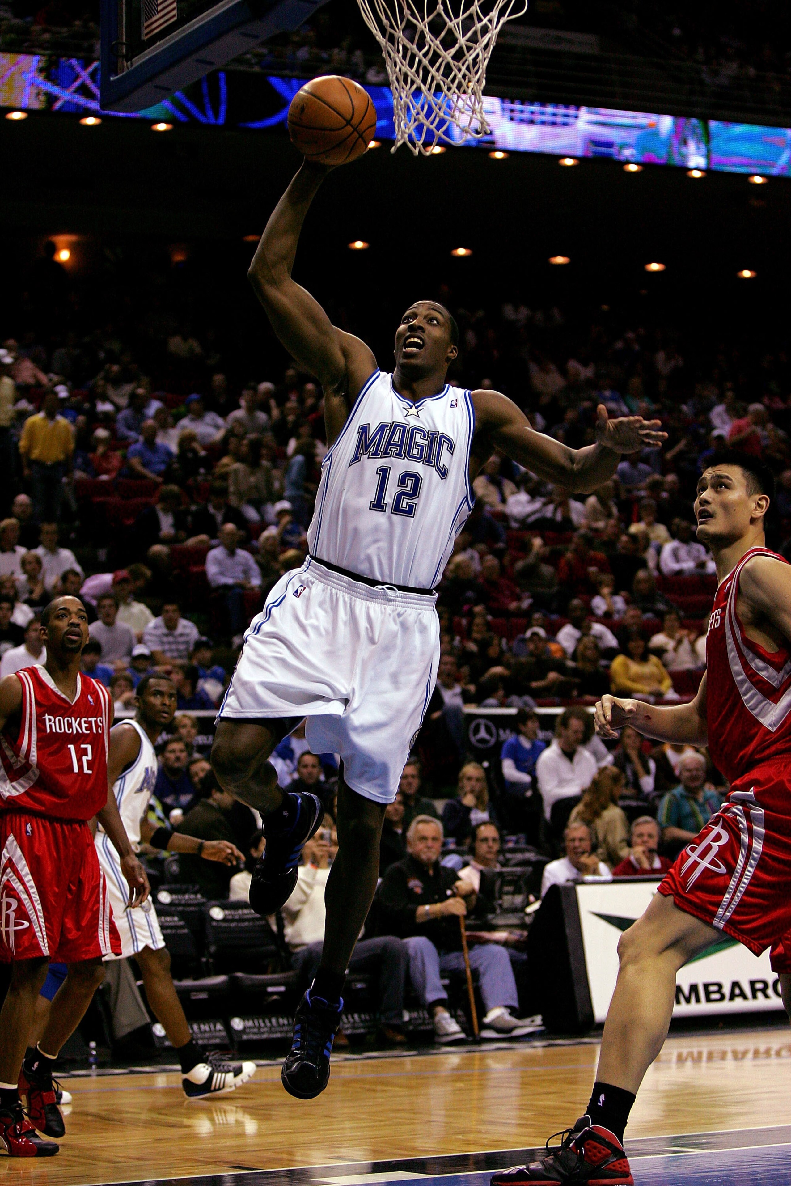 ORLANDO, FL - JANUARY 4:  Dwight Howard #12 of the Orlando Magic drives to the basket against Yao Ming #11 of the Houston Rockets at Amway Arena January 4, 2008 in Orlando Florida. NOTE TO USER: User expressly acknowledges and agrees that, by downloading