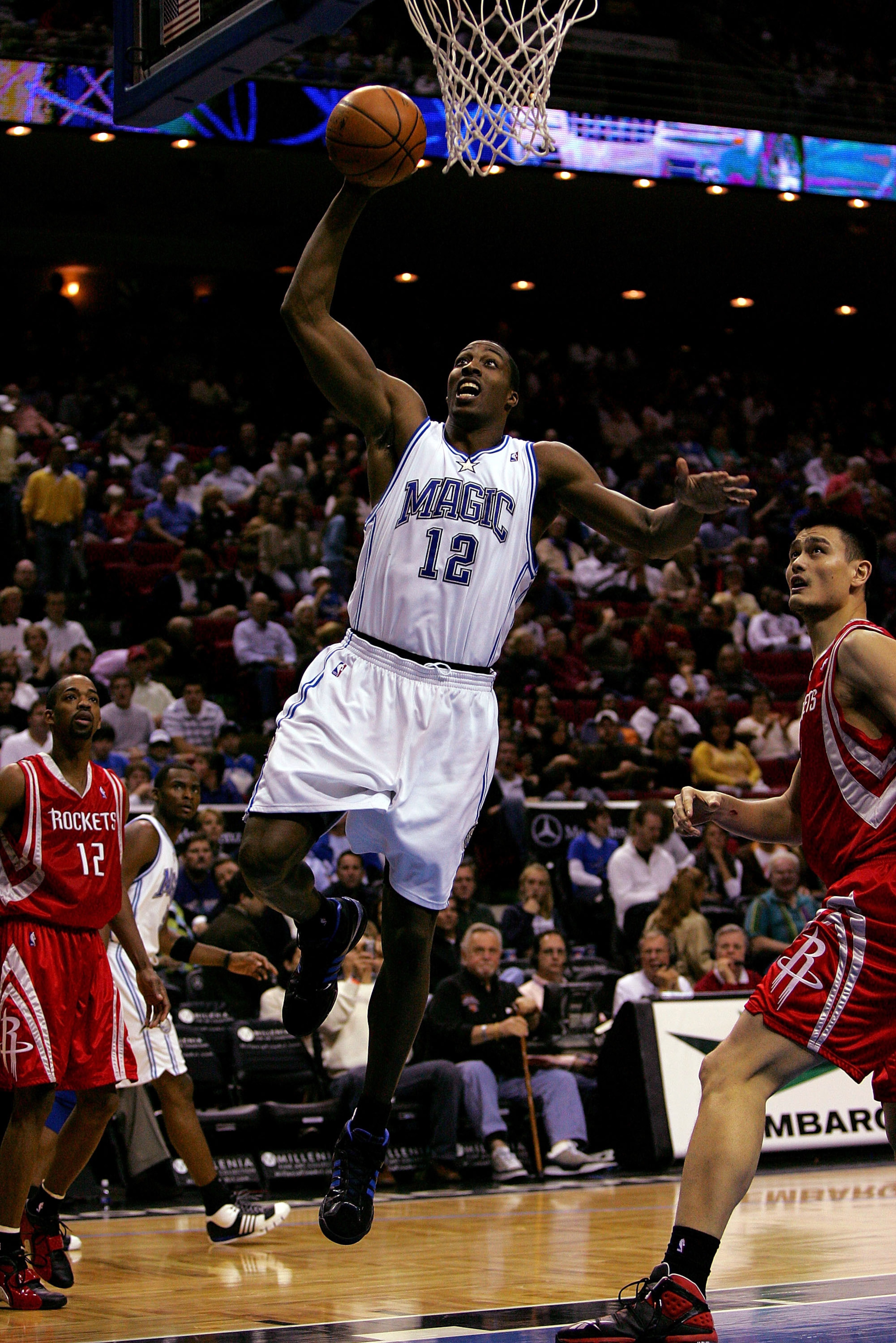 ORLANDO, FL - JANUARY 4:  Dwight Howard #12 of the Orlando Magic drives to the basket against Yao Ming #11 of the Houston Rockets at Amway Arena January 4, 2008 in Orlando Florida. NOTE TO USER: User expressly acknowledges and agrees that, by downloading