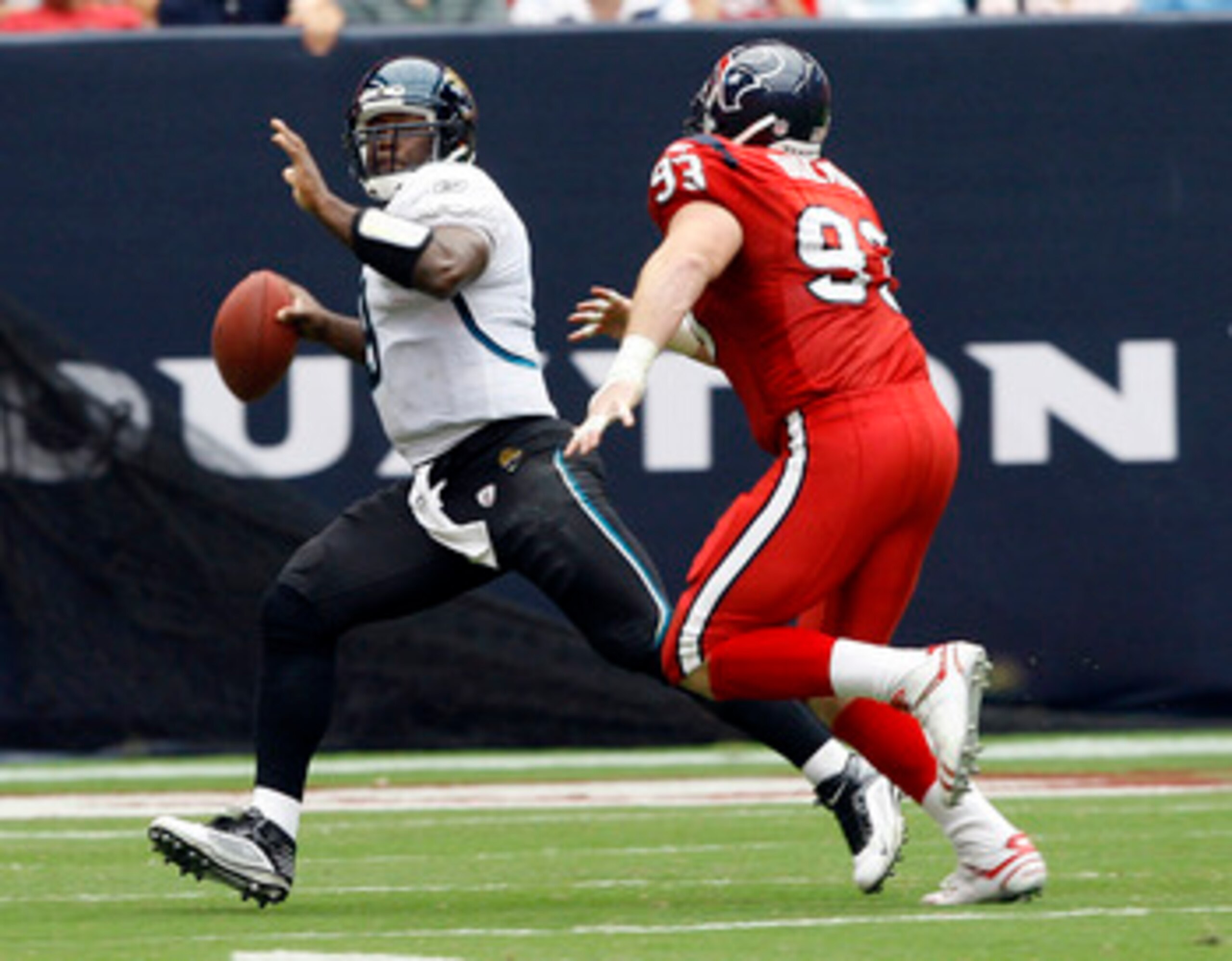 HOUSTON - SEPTEMBER 27:  Quarterback David Garrard #9 of the Jacksonville Jaguars runs out of the pocket as he his pursued by defensive end Tim Bulman #93 of the Houston Texans at Reliant Stadium on September 27, 2009 in Houston, Texas.  (Photo by Bob Lev