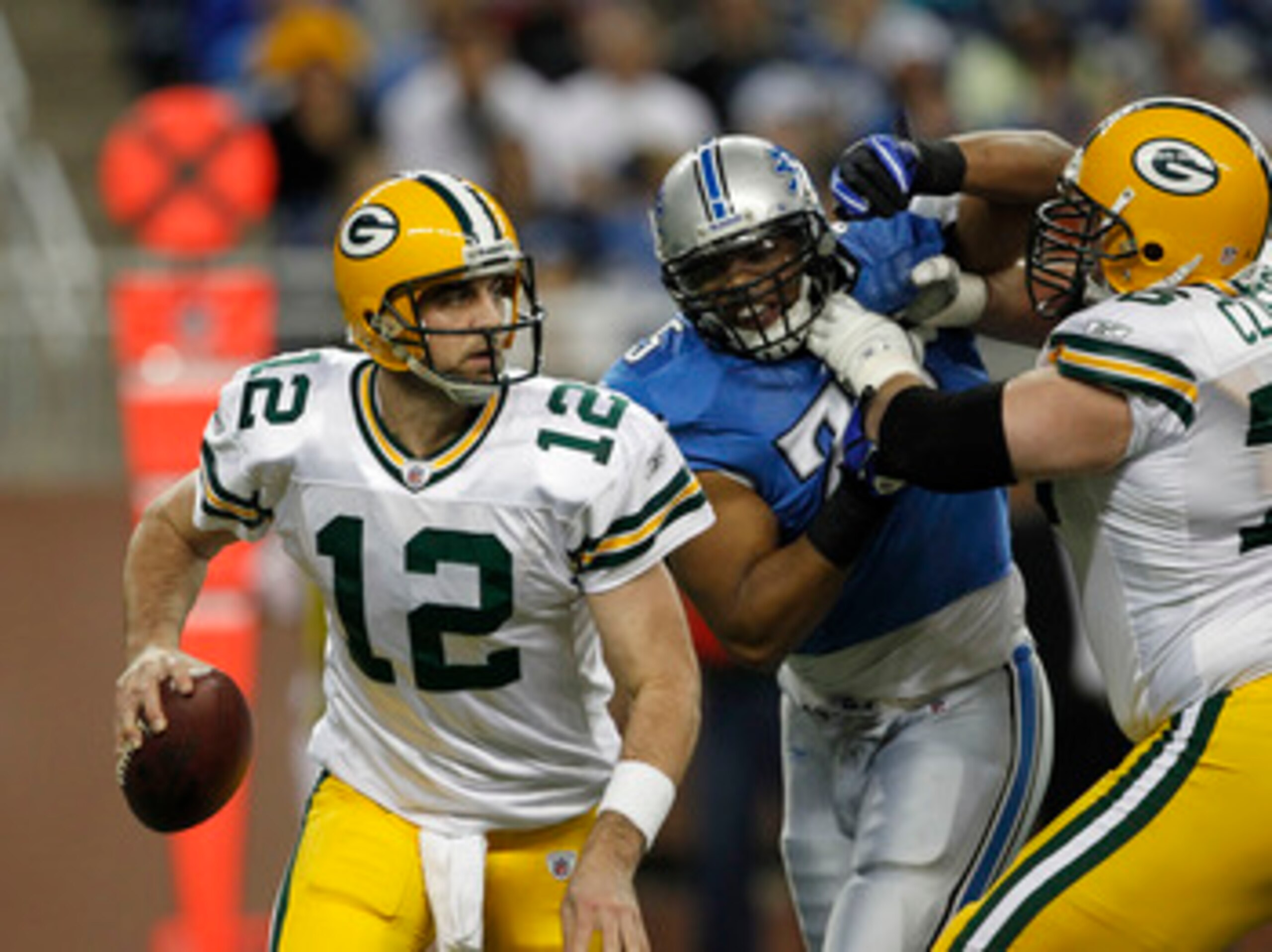 DETROIT - DECEMBER 12: Aaron Rogers #12 of the Green Bay Packers rolls out to pass as Chad Clifton #76 of the Green Bay Packers blocks Turk McBride #75 of the Detroit lions during the second quarter of the game against the Detroit Lions at Ford Field on DETROIT - DECEMBER 12: Aaron Rogers #12 of the Green Bay Packers rolls out to pass as Chad Clifton #76 of the Green Bay Packers blocks Turk McBride #75 of the Detroit lions during the second quarter of the game against the Detroit Lions at Ford Field on