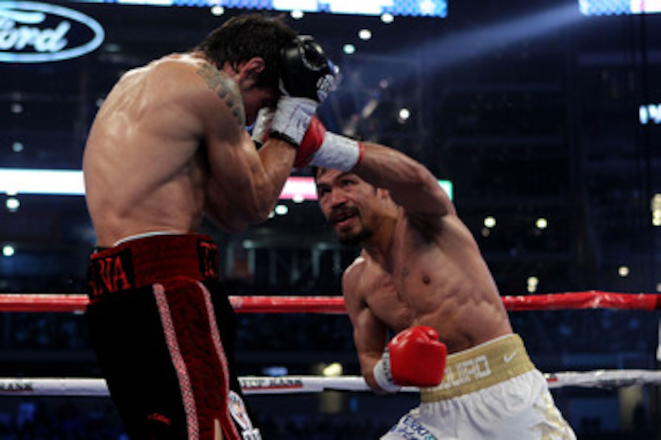 ARLINGTON, TX - NOVEMBER 13:  Manny Pacquiao (R in white trunks) of the Philippines lands a punch against Antonio Margarito (black trunks) of Mexico during their WBC World Super Welterweight Title bout at Cowboys Stadium on November 13, 2010 in Arlington,