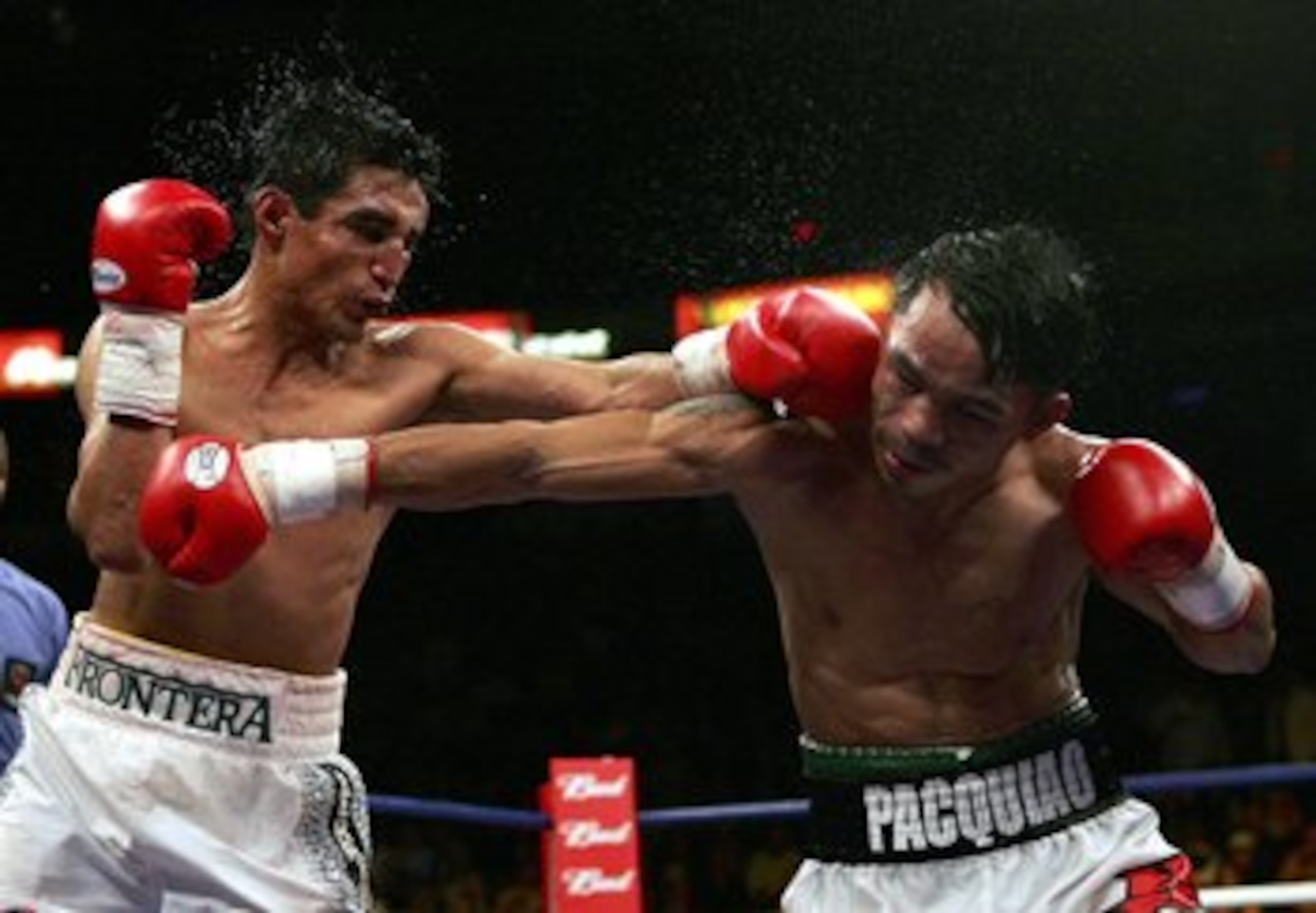 LAS VEGAS - JANUARY 21:  (L-R)  Erik Morales of Mexico throws a left at Manny Pacquiao of the Phillippines during their Super Featherweight Championship fight at Thomas & Mack Arena on January 21, 2006 in Las Vegas, Nevada.  (Photo by Jed Jacobsohn/Getty