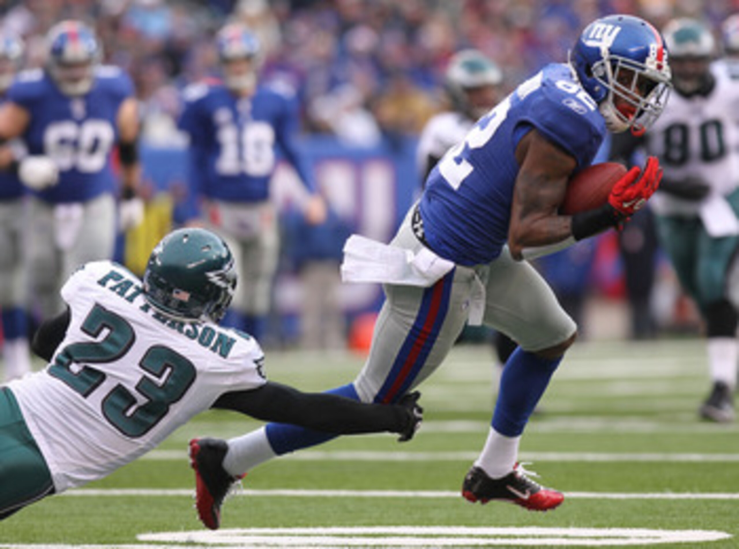 EAST RUTHERFORD, NJ - DECEMBER 19:  Mario Manningham #82 of the New York Giants turns out of the tackle of Dimitri Patterson #23 of the Philadelphia Eagles on his way to a touchdown at New Meadowlands Stadium on December 19, 2010 in East Rutherford, New J