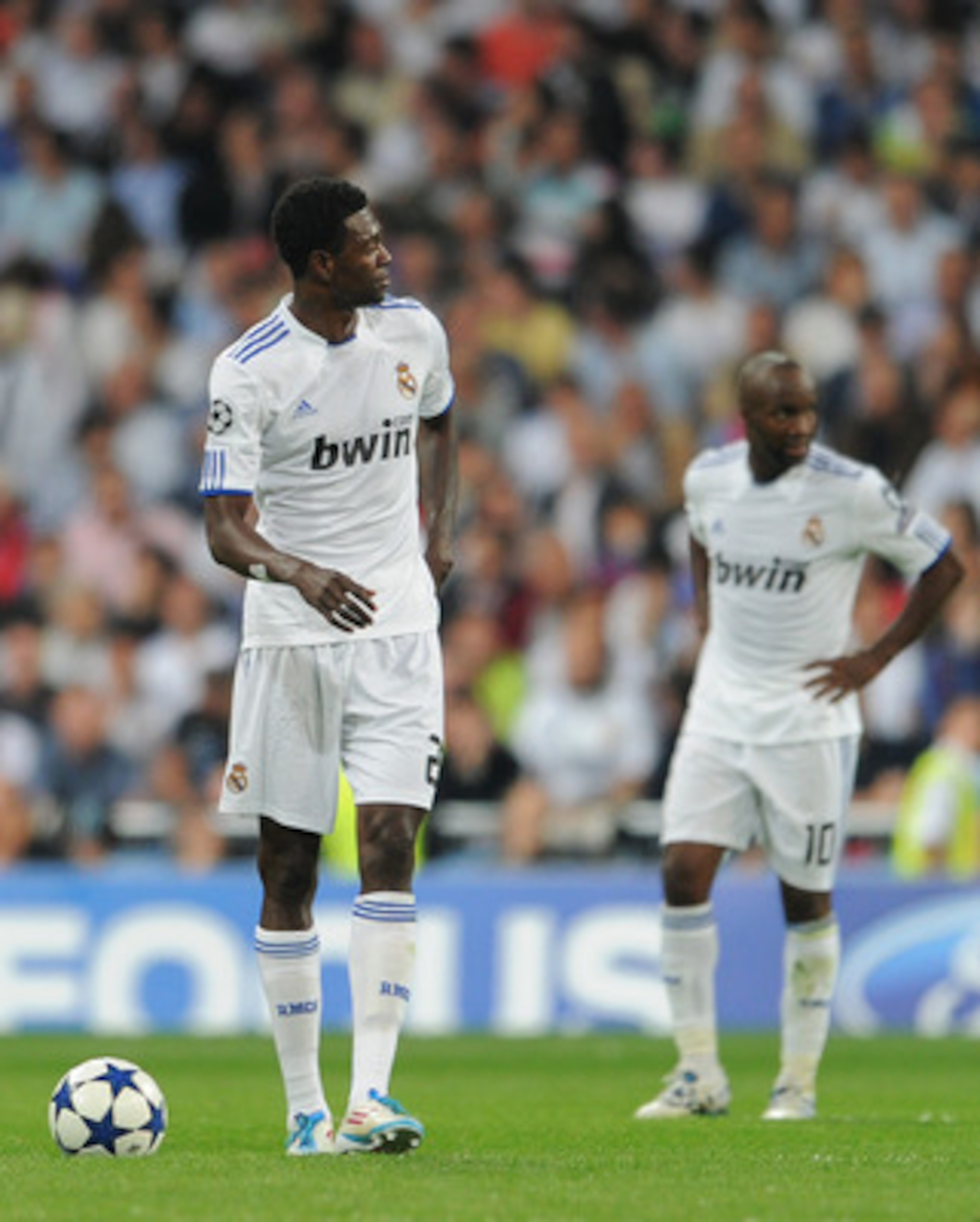 MADRID, SPAIN - APRIL 27:  Emmanuel Adebayor (L) of Real Madrid trudges back to the halfway line backdropped by his teammate Lassana Diarra after conceding a goal during the UEFA Champions League Semi Final first leg match between Real Madrid and Barcelon