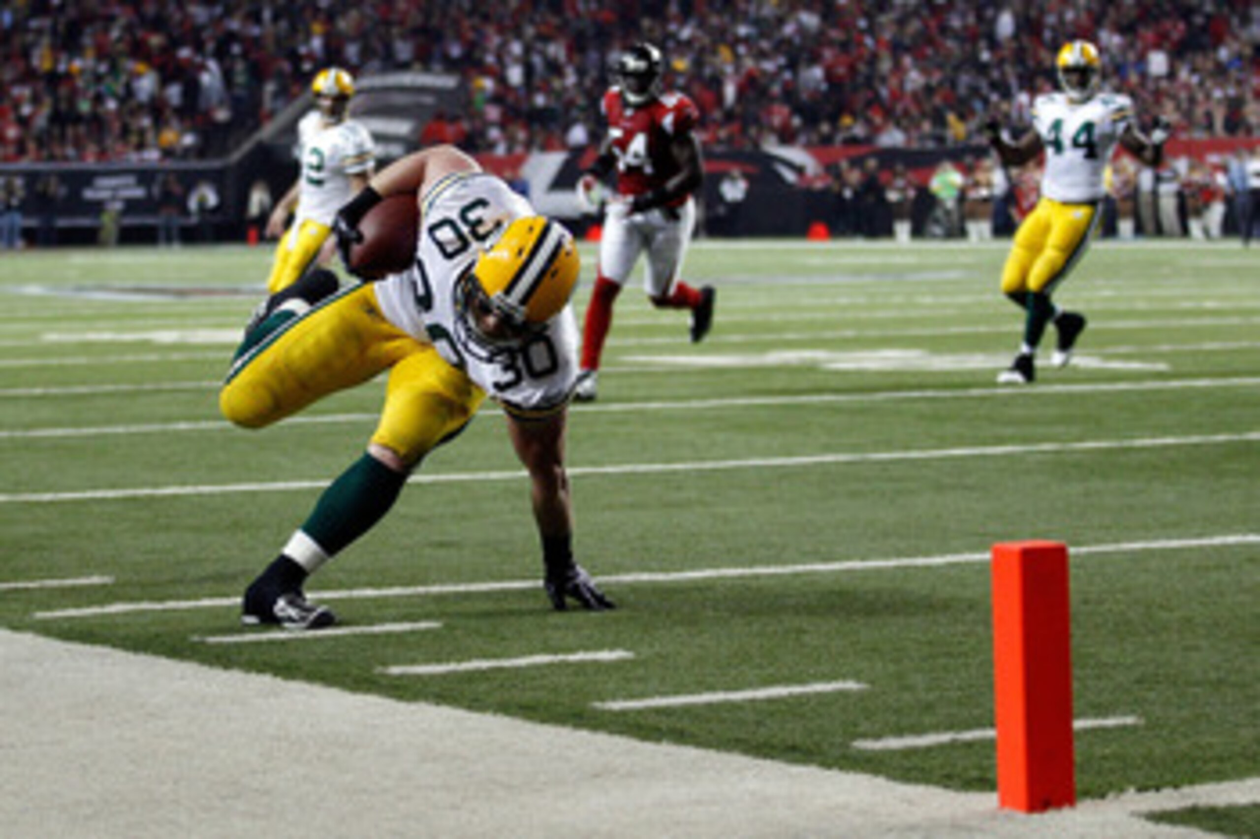 ATLANTA, GA - JANUARY 15:  John Kuhn #30 of the Green Bay Packers scores a 7-yard touchdown reception against the Atlanta Falcons during their 2011 NFC divisional playoff game at Georgia Dome on January 15, 2011 in Atlanta, Georgia.  (Photo by Chris Grayt