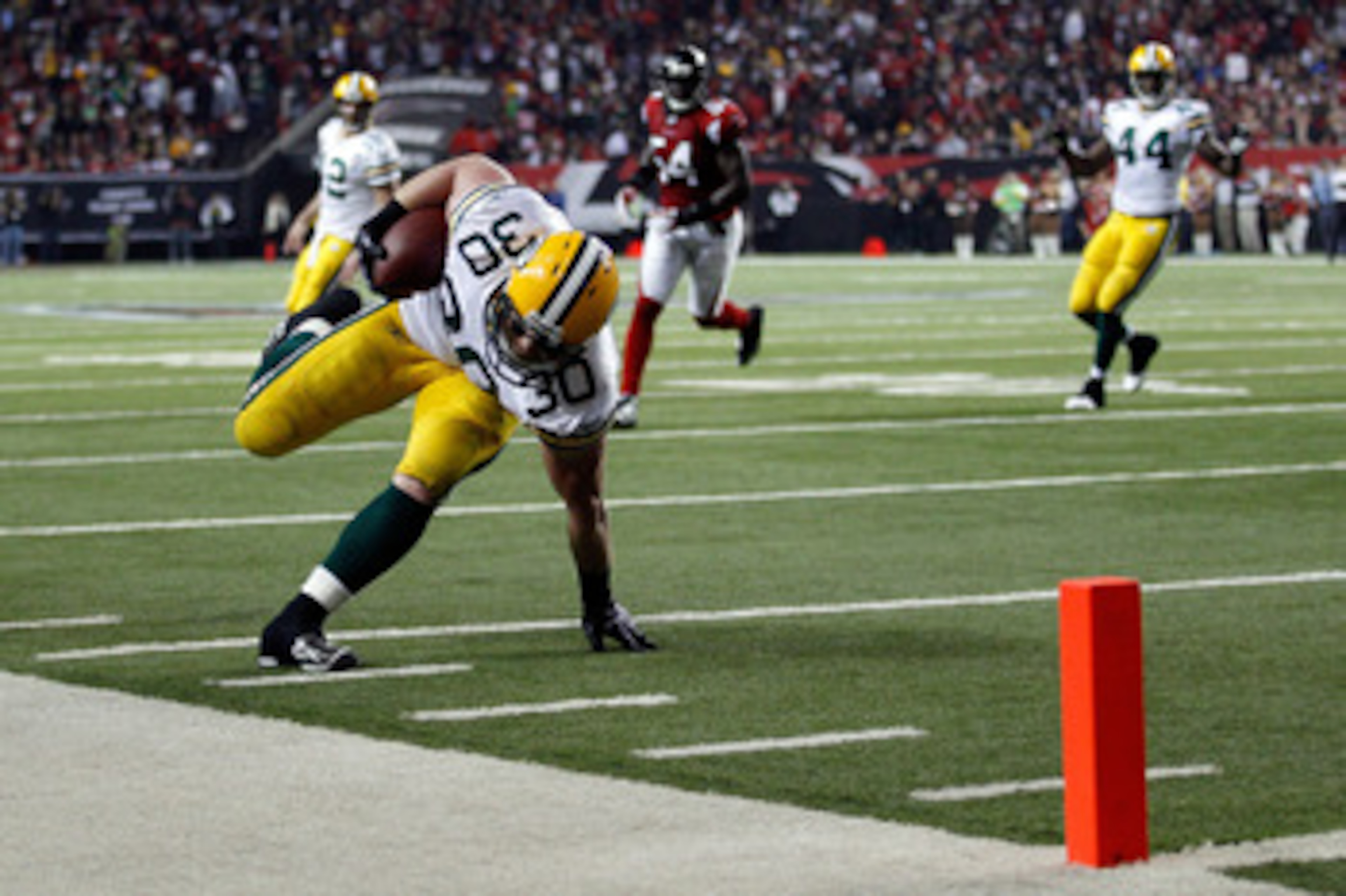 ATLANTA, GA - JANUARY 15:  John Kuhn #30 of the Green Bay Packers scores a 7-yard touchdown reception against the Atlanta Falcons during their 2011 NFC divisional playoff game at Georgia Dome on January 15, 2011 in Atlanta, Georgia.  (Photo by Chris Grayt