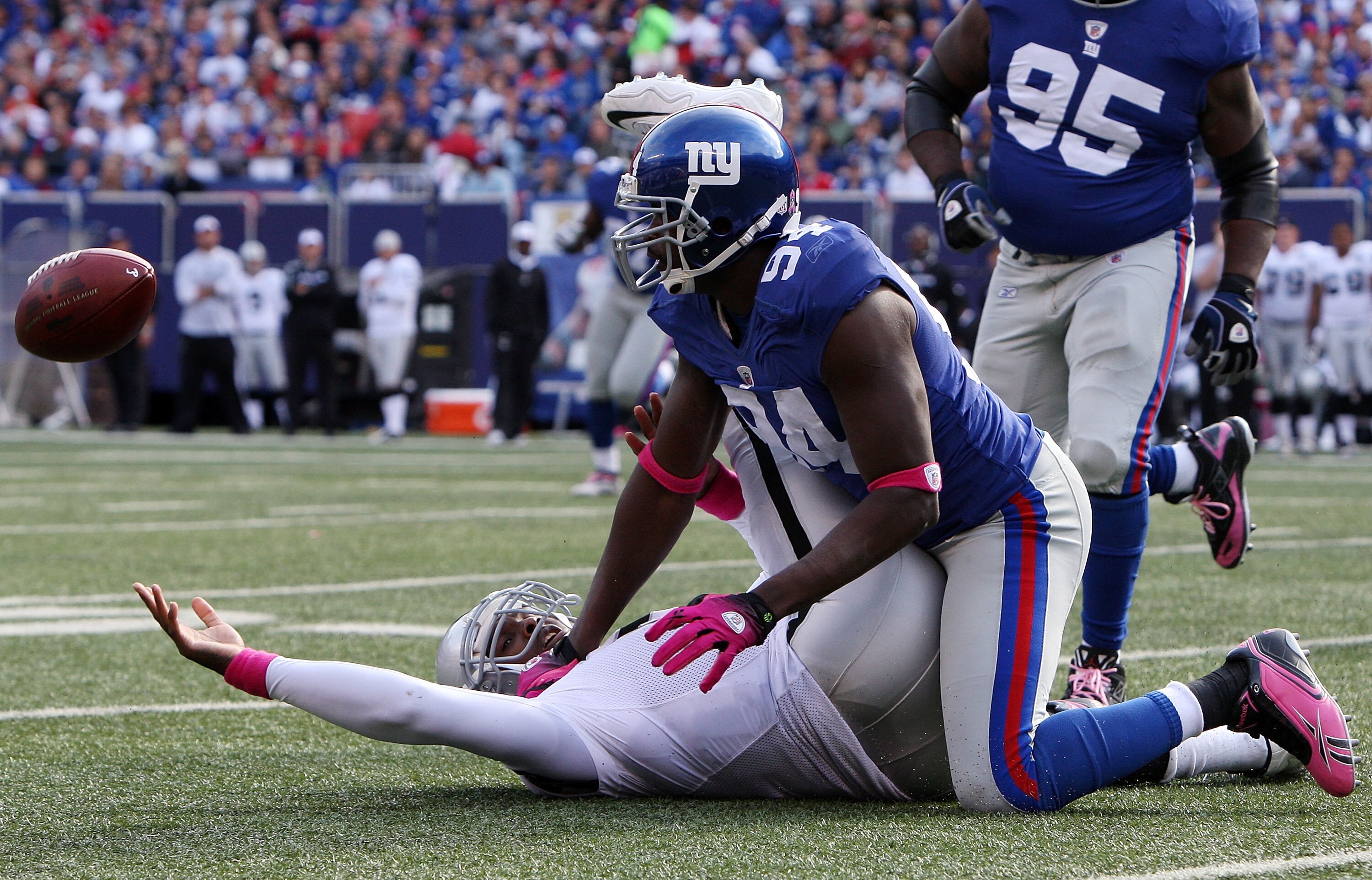 EAST RUTHERFORD, NJ - OCTOBER 11:  Mathias Kiwanuka #94 of the New York Giants forces a fumble against JaMarcus Russell #2 of the Oakland Raiders on October 11, 2009 at Giants Stadium in East Rutherford, New Jersey. The Giants defeated the Raiders 44-7.