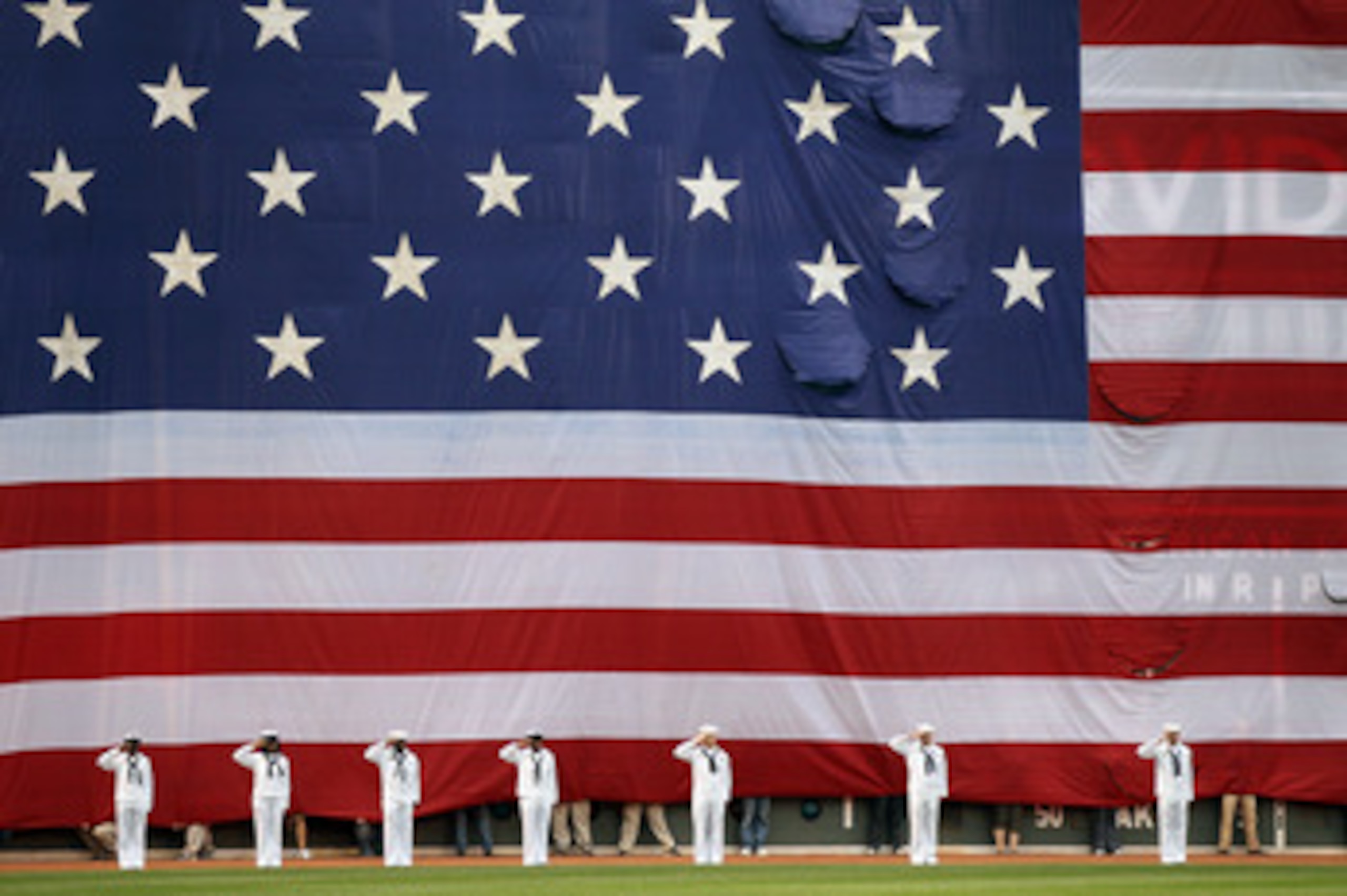 BOSTON, MA - MAY 02:  A giant flag covers the Green Monster as the national anthem is played before the game between the Boston Red Sox and the Los Angeles Angels on May 2, 2011 at Fenway Park in Boston, Massachusetts.  Both teams lined up on the baseline