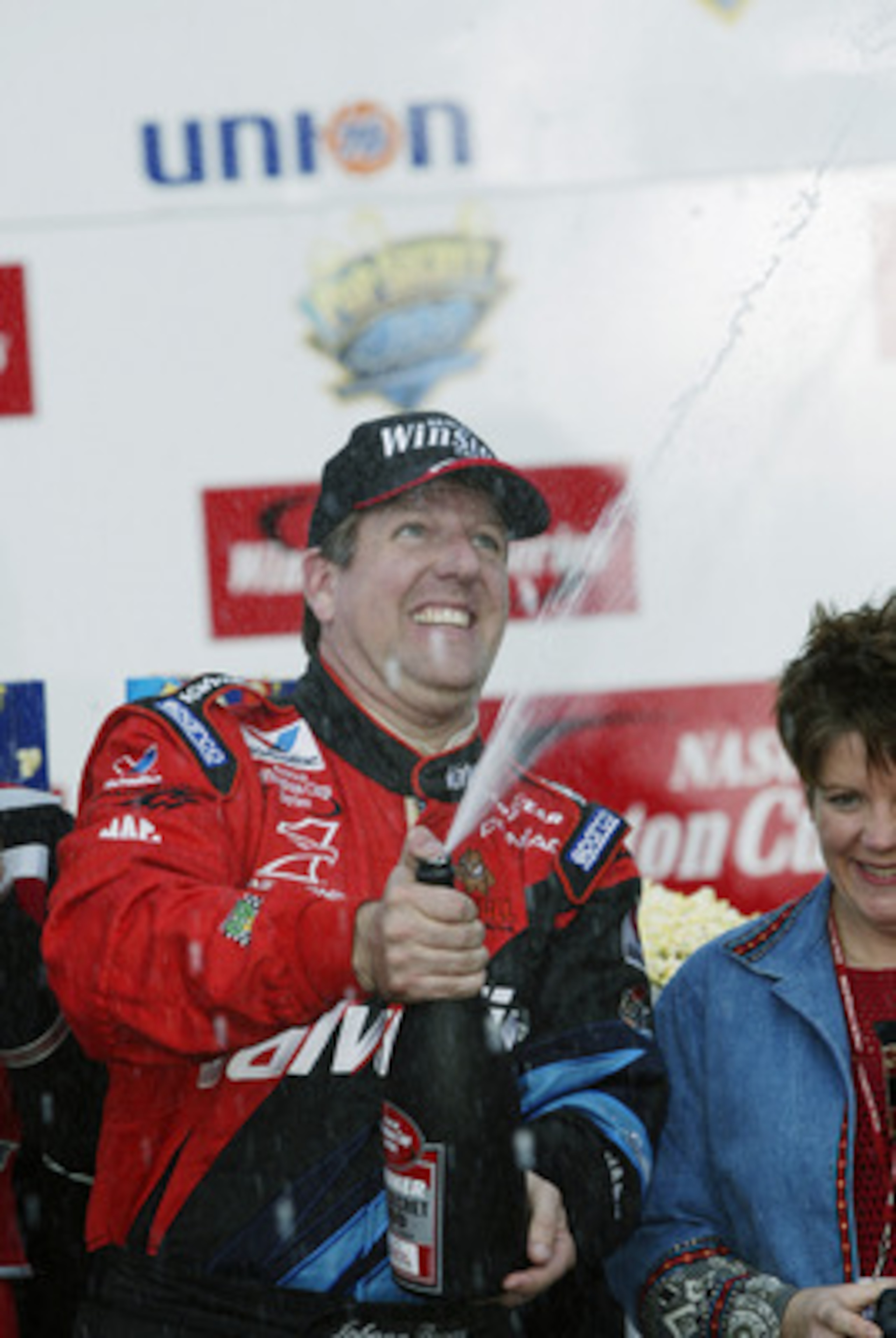 ROCKINGHAM, NC - NOVEMBER 3:  Johnny Benson #10, driver of the Valvoline Pontiac, celebrates winning the Pop Secret Microwave Popcorn 400 on November 3, 2002 at North Carolina Speedway in Rockingham, North Carolina.   (Photo by Craig Jones/Getty Images)