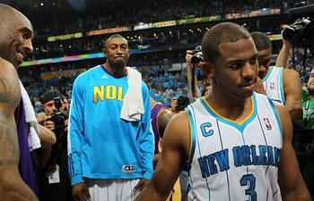 NEW ORLEANS, LA - APRIL 28:  Chris Paul #3 of the New Orleans Hornets walks off the court after a 98-80 loss as Kobe Bryant #24 of the Los Angeles Lakers smiles after winning the series in Game Six of the Western Conference Quarterfinals in the 2011 NBA P