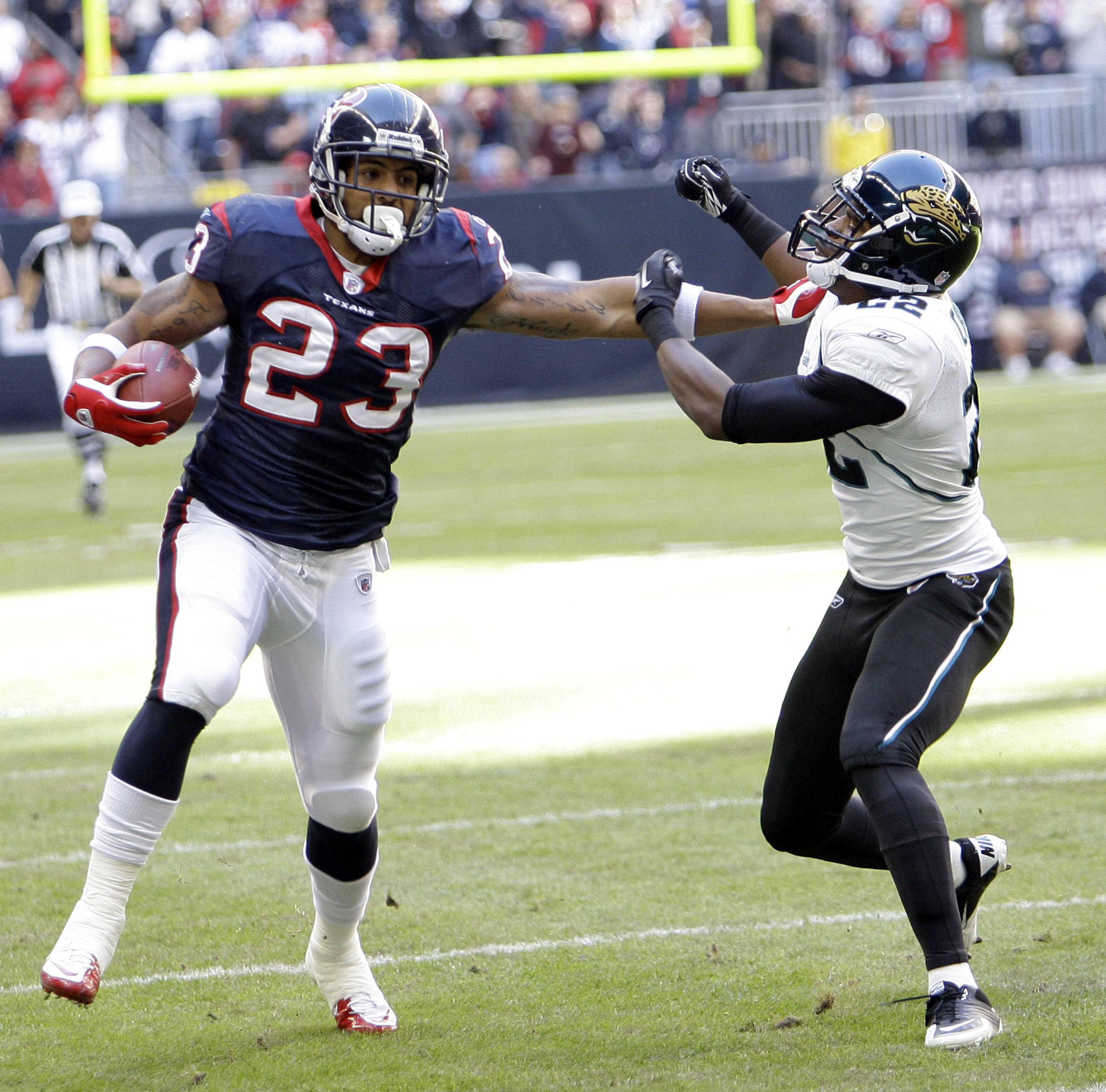 HOUSTON - JANUARY 02:  Running back Arian Foster #23 of the Houston Texans gives Don Carey #22 of the Jacksonville Jaguars a stiff arm at Reliant Stadium on January 2, 2011 in Houston, Texas.  (Photo by Bob Levey/Getty Images)