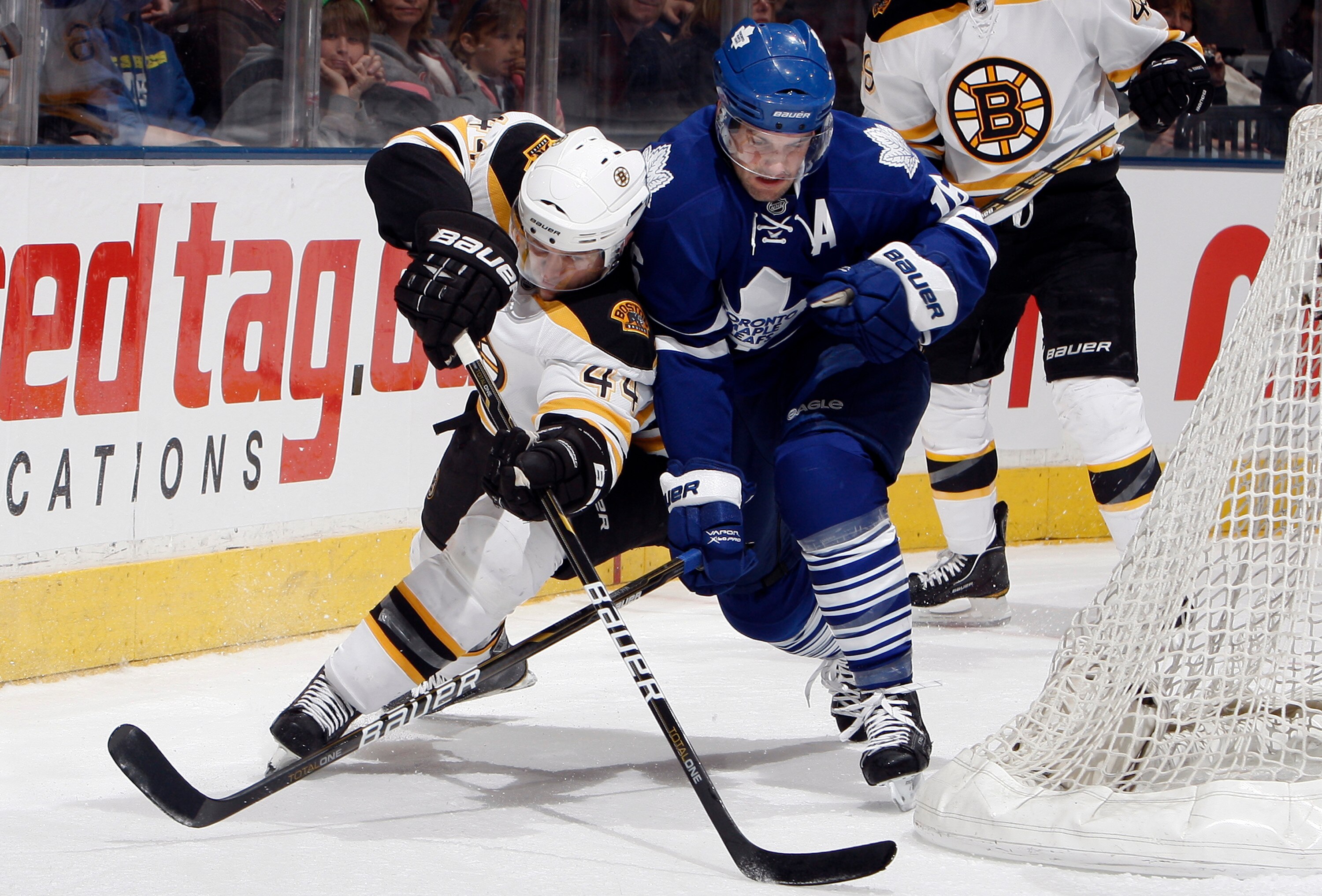 TORONTO, CANADA - MARCH 19 Dennis Seidenberg #44 of the Boston Bruins battles for the puck with Clarke MacArthur #16 of the Toronto Maple Leafs during game action at the Air Canada Centre March 19, 2011 in Toronto, Ontario, Canada. (Photo by Abelimages/Ge