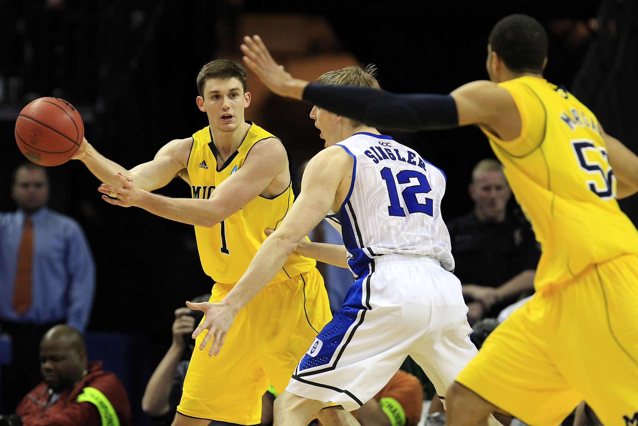 CHARLOTTE, NC - MARCH 20:  Stu Douglass #1 of the Michigan Wolverines looks to pass around Kyle Singler #12 of the Duke Blue Devils during the third round of the 2011 NCAA men's basketball tournament at Time Warner Cable Arena on March 20, 2011 in Charlot