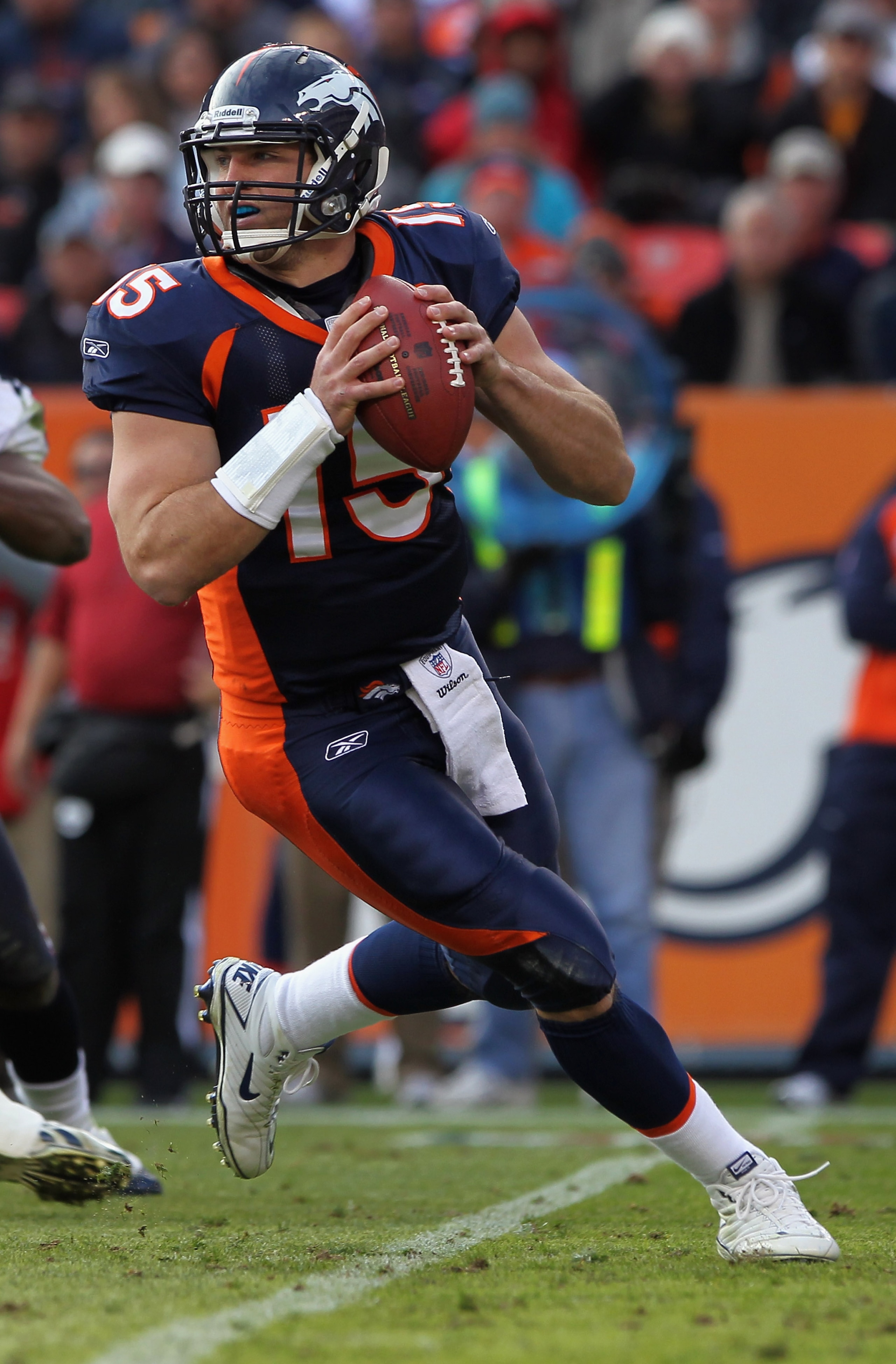 DENVER - DECEMBER 26: Quarterback Tim Tebow #15 of the Denver Broncos rolls out and looks to deliver a pass against the Houston Texas at INVESCO Field at Mile High on December 26, 2010 in Denver, Colorado. The Broncos defeated the Texans 24-23. (Photo b DENVER - DECEMBER 26: Quarterback Tim Tebow #15 of the Denver Broncos rolls out and looks to deliver a pass against the Houston Texas at INVESCO Field at Mile High on December 26, 2010 in Denver, Colorado. The Broncos defeated the Texans 24-23. (Photo b