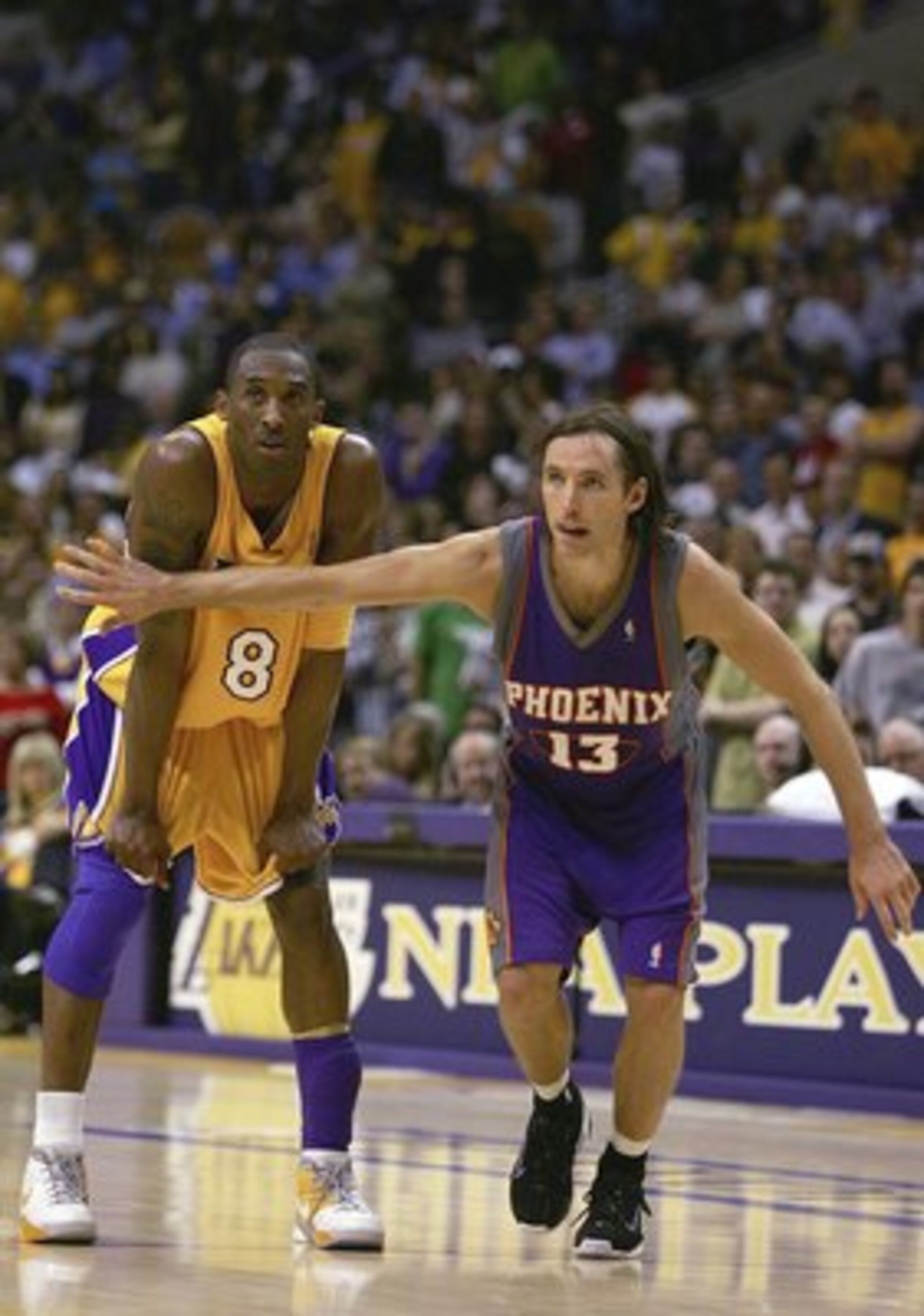 LOS ANGELES - MAY 4:  Steve Nash #13 of the Phoenix Suns puts his arm in front of Kobe Bryant #8 of the Los Angeles Lakers in game six of the Western Conference Quarterfinals during the 2006 NBA Playoffs on May 4, 2006 at the Staples Center in Los Angeles