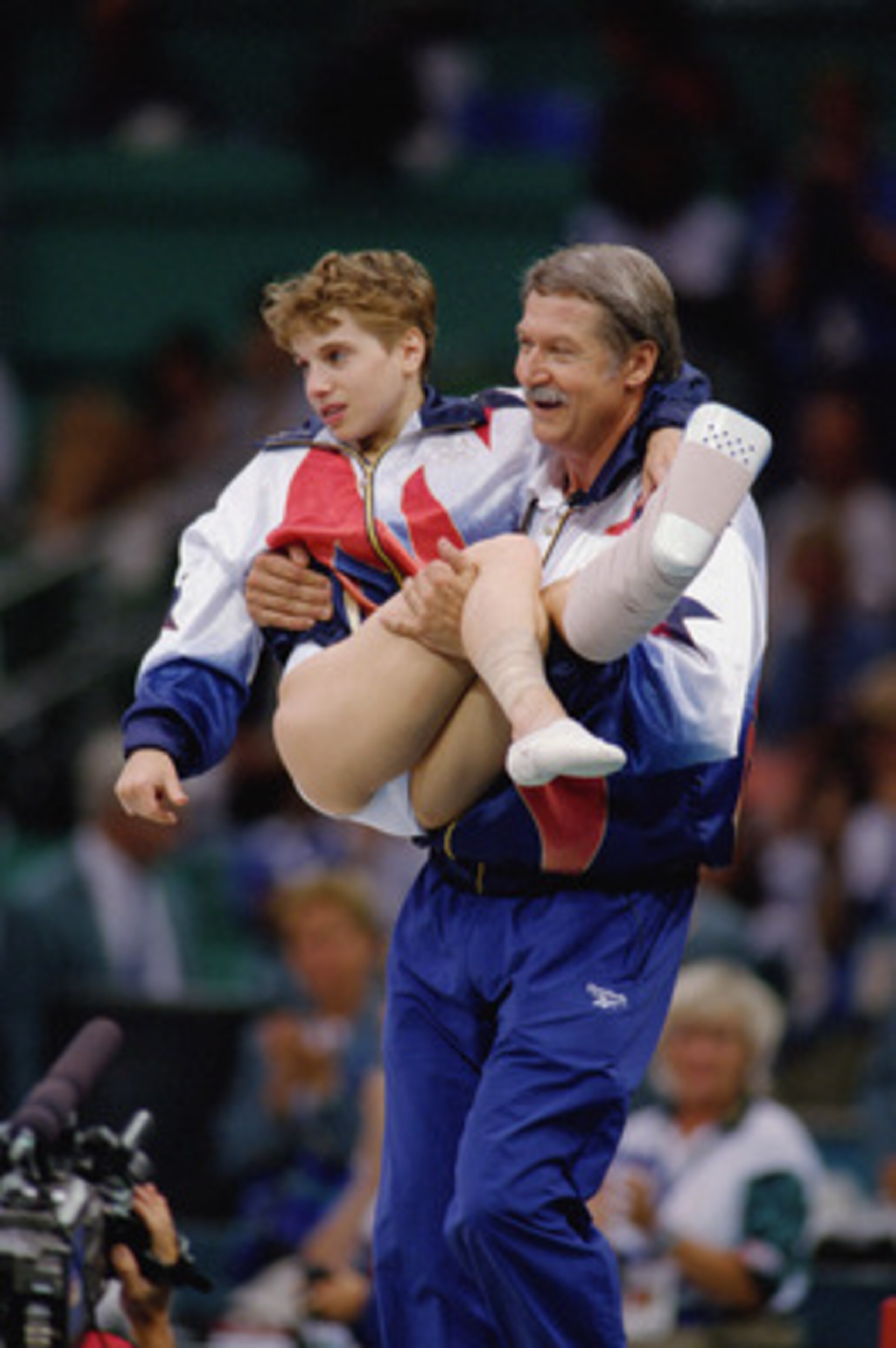 ATLANTA - JULY 23:  Coach Bela Karolyi carries Kerri Strug of the United States after she injured herself on her first attempt while competing in the vault, part of the Womens Team Gymnastics competition at the 1996 Olympic Games on July 23, 1996 at the G