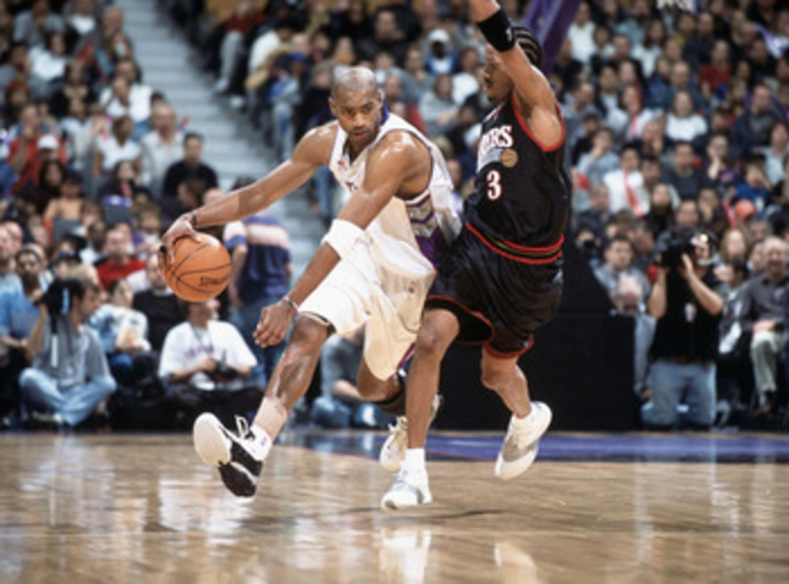 25 Nov 2001: Vince Carter #15 of the Toronto Raptors dribbles the ball to the key as he is guarded by Allen Iverson #3 of the Philadelphia 76ers during the game at Air Canada Centre in Toronto, Canada. The Raptors defeated the 76ers 107-88. TO USER: User