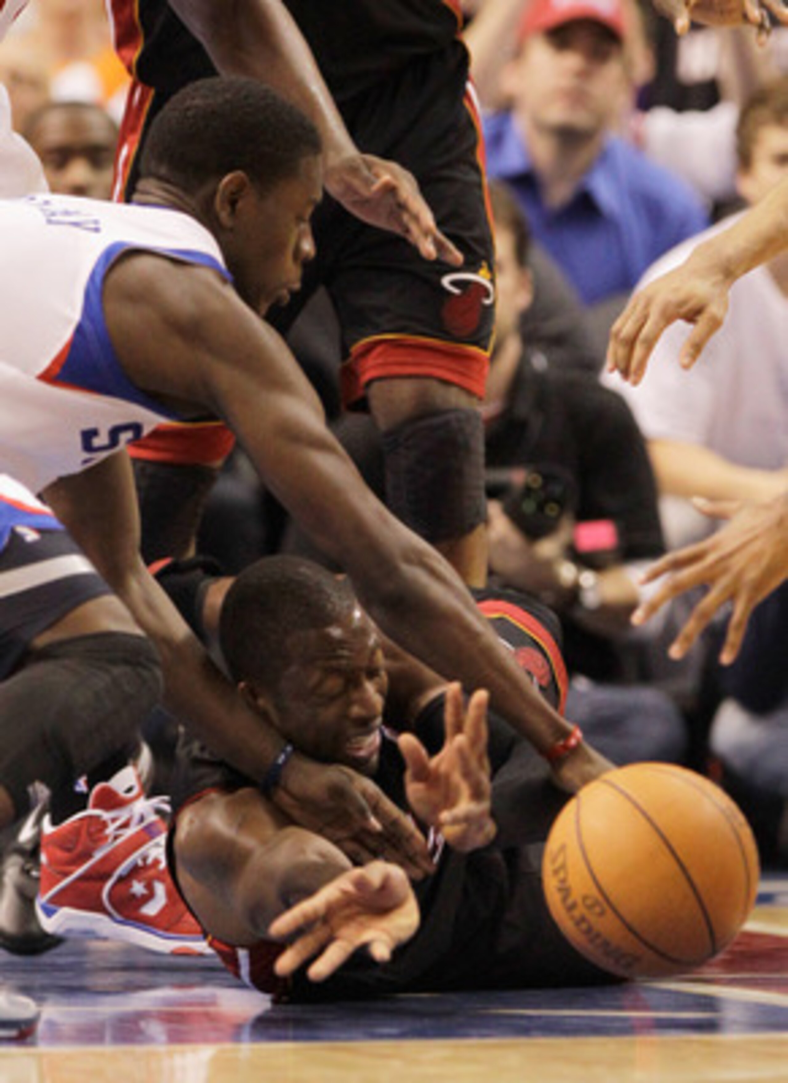 PHILADELPHIA, PA - APRIL 21:  Jrue Holiday #11 of the Philadelphia 76ers (L) and Dwyane Wade #3 of the Miami Heat (R) go after a loose ball during the second half of game three of the Eastern Conference Quarterfinals at Wells Fargo Center on April 21, 201