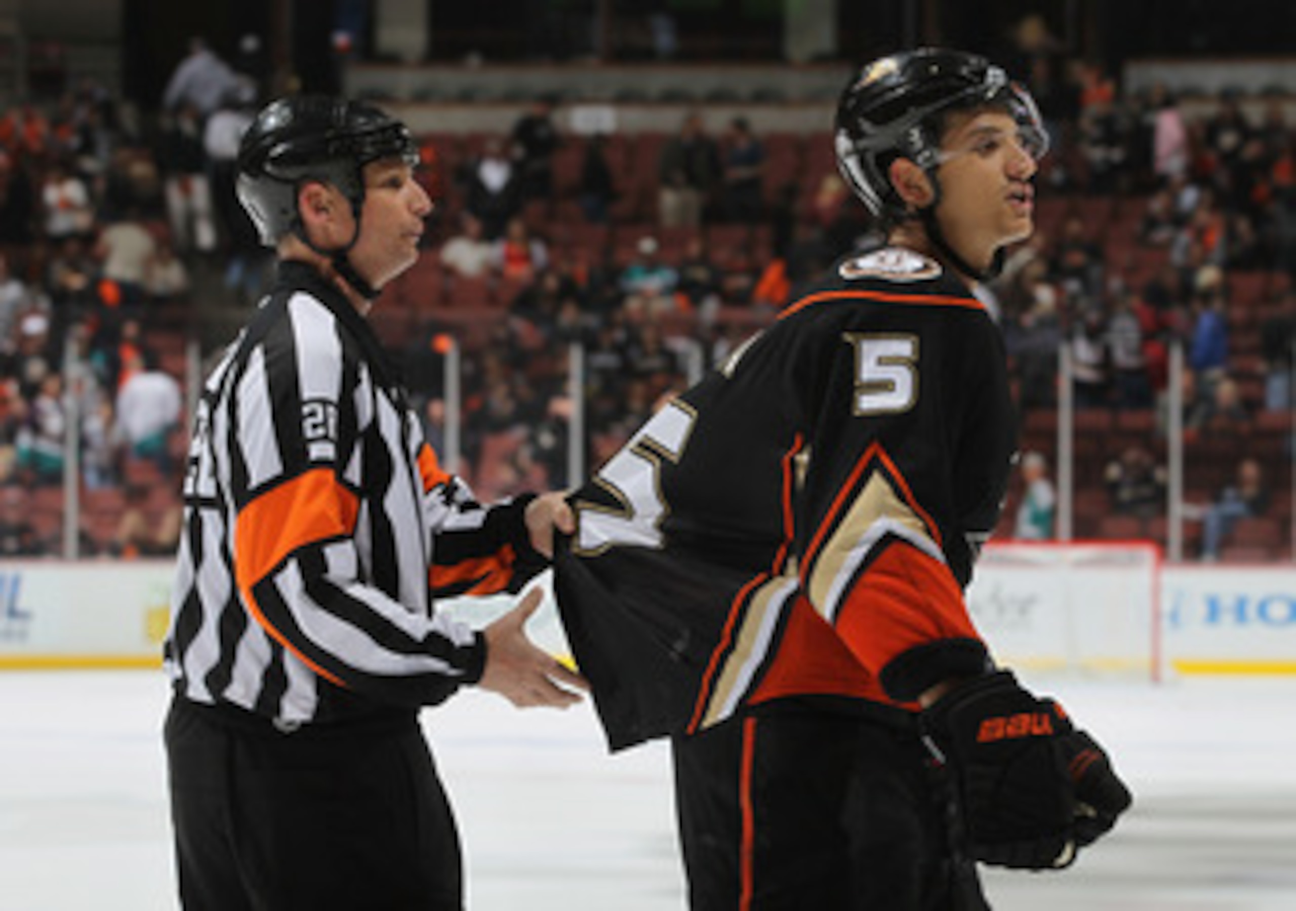 ANAHEIM, CA - APRIL 13:  Luca Sbisa #5 of the Anaheim Ducks is restrained by referee Chris Lee in the third period against the Nashville Predators in Game One of the Western Conference Quarterfinals during the 2011 NHL Stanley Cup Playoffs at Honda Center
