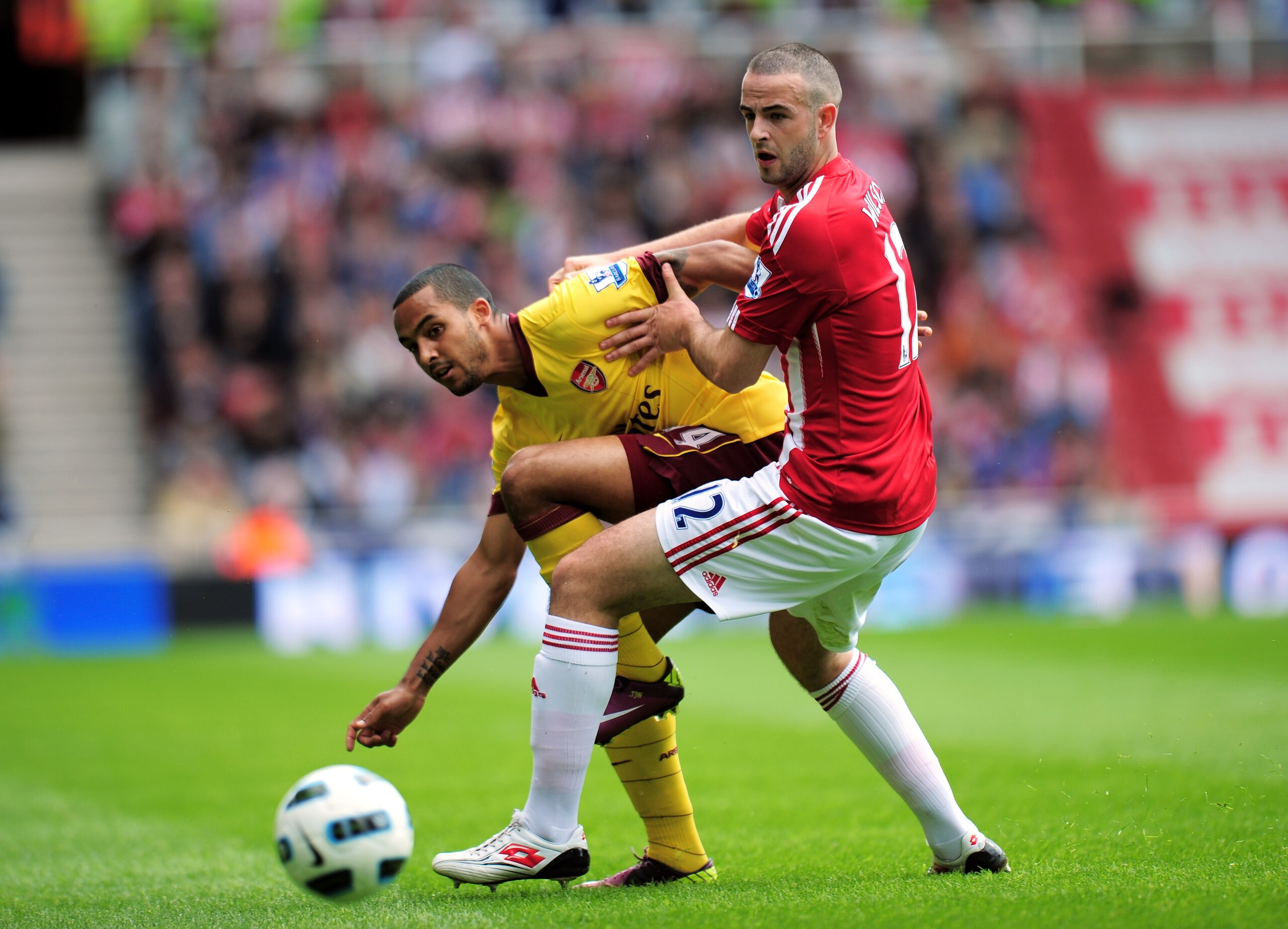 STOKE ON TRENT, ENGLAND - MAY 08:  Theo Walcott of Arsenal is challenged by Marc Wilson of Stoke during the Barclays Premier League match between Stoke City and Arsenal at the Britannia Stadium on May 8, 2011 in Stoke on Trent, England.  (Photo by Shaun B