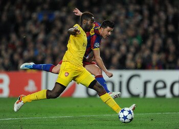 BARCELONA, SPAIN - MARCH 08:  David Villa (R) of Barcelona shoots on goal past Johan Djourou of Arsenal during the UEFA Champions League round of 16 second leg match between Barcelona and Arsenal on March 8, 2011 in Barcelona, Spain.  (Photo by Jasper Jui