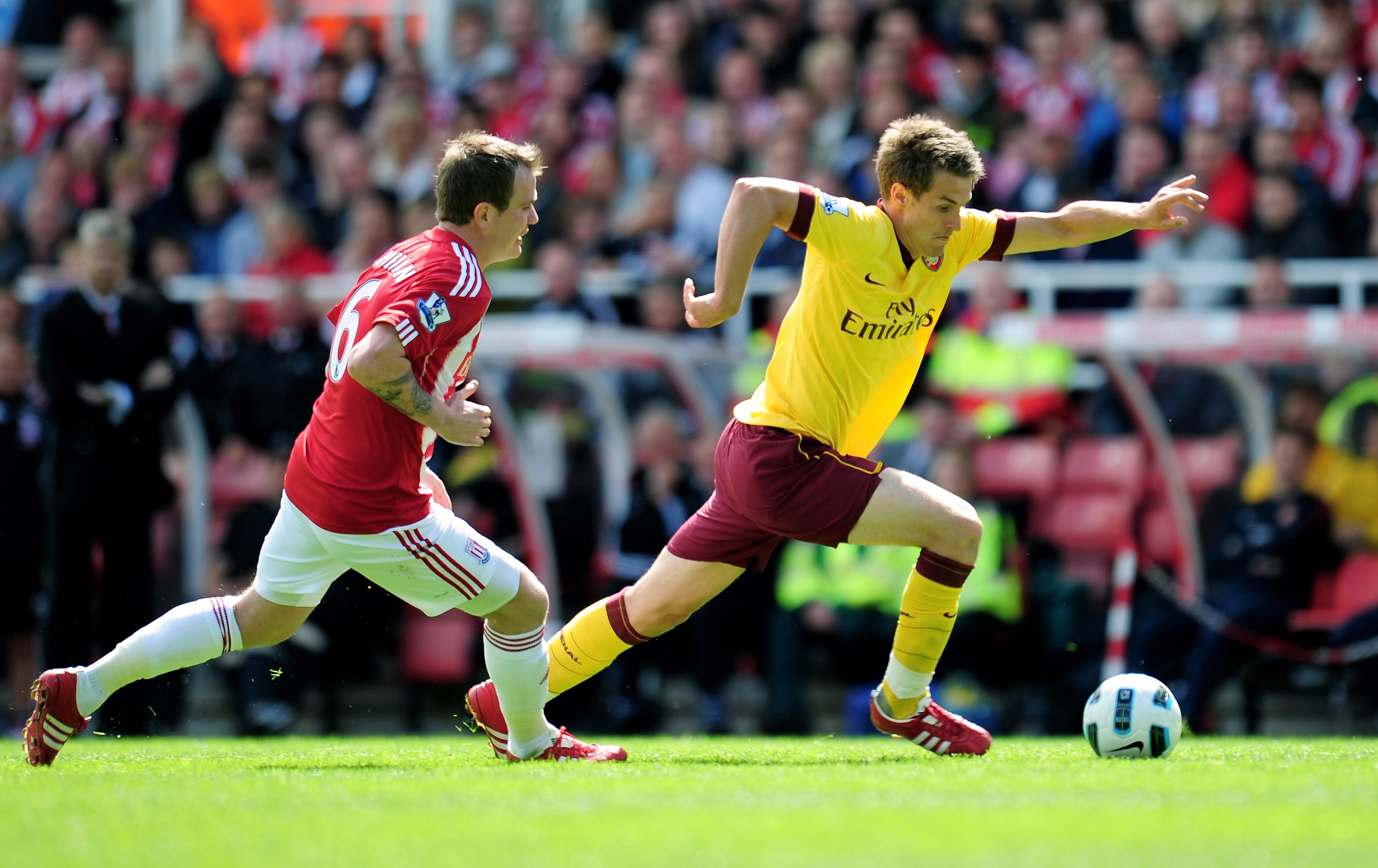 STOKE ON TRENT, ENGLAND - MAY 08:  Aaron Ramsey of Arsenal is pursued by Glenn Whelan of Stoke during the Barclays Premier League match between Stoke City and Arsenal at the Britannia Stadium on May 8, 2011 in Stoke on Trent, England.  (Photo by Shaun Bot