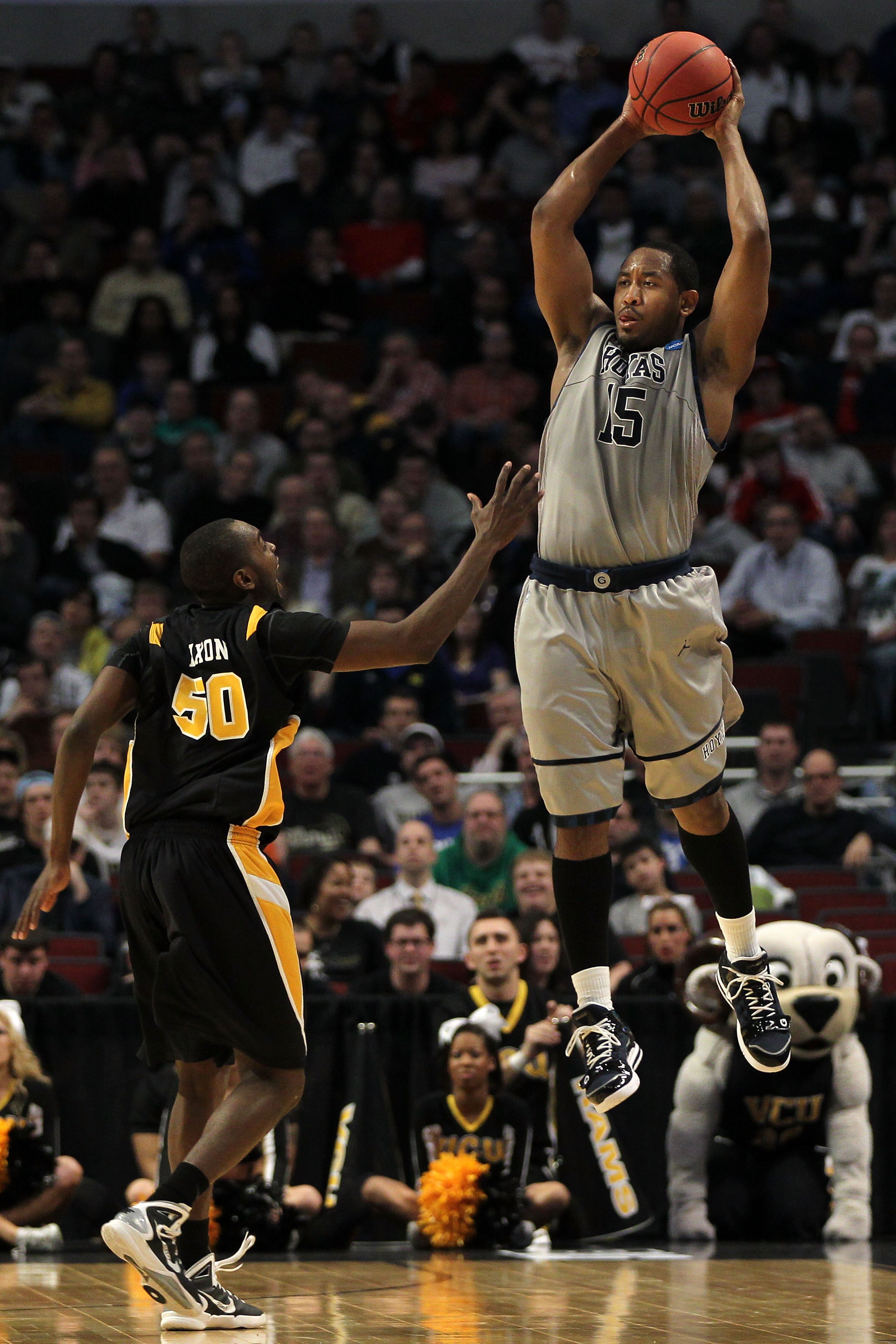 CHICAGO, IL - MARCH 18: Austin Freeman #15 of the Georgetown Hoyas looks to pass against Ed Nixon #50 of the Virginia Commonwealth Rams in the first half during the second round of the 2011 NCAA men's basketball tournament at the United Center on March 18